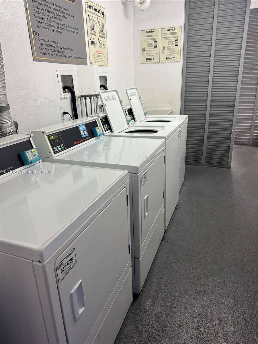 3475 N Country Club Drive, #704, Aventura, Aventura, FL 33180 Communal laundry room featuring multiple commercial-grade top-load washers and dryers, louvered closet doors, and smooth-finish flooring