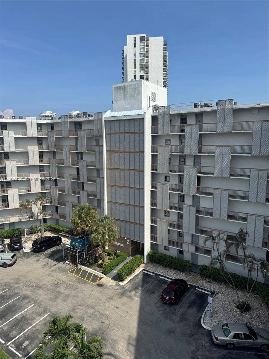 3475 N Country Club Drive, #704, Aventura, Aventura, FL 33180 Multi-story residential complex featuring geometric facade detailing, exterior-facing balconies, and dedicated surface parking
