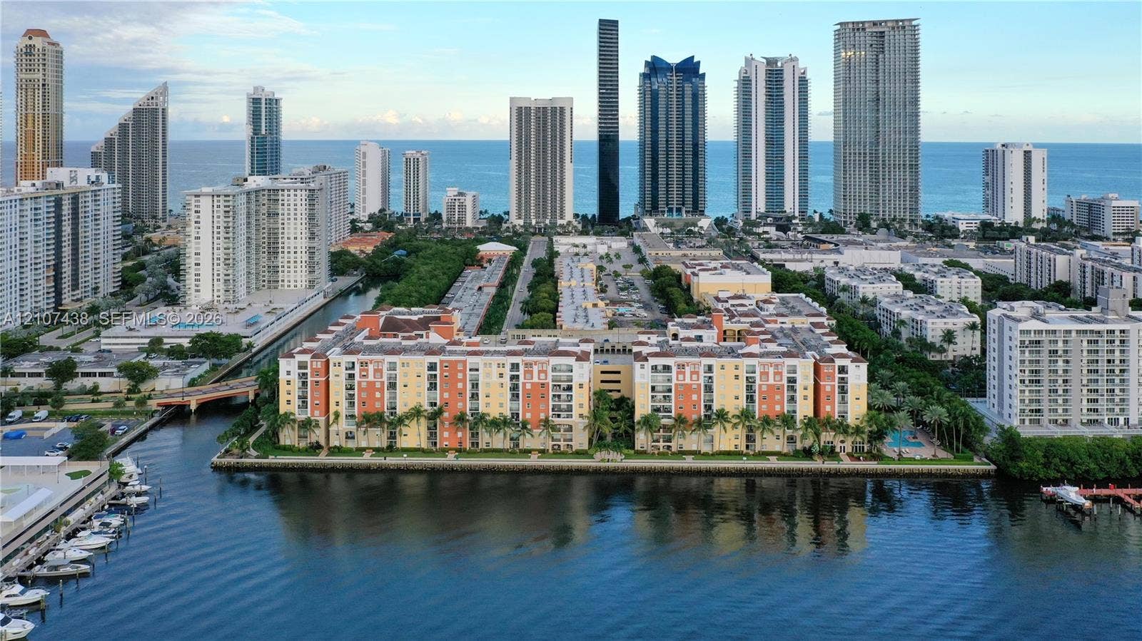 Waterfront multi-story residential complex featuring landscaped grounds and immediate access to canal frontage