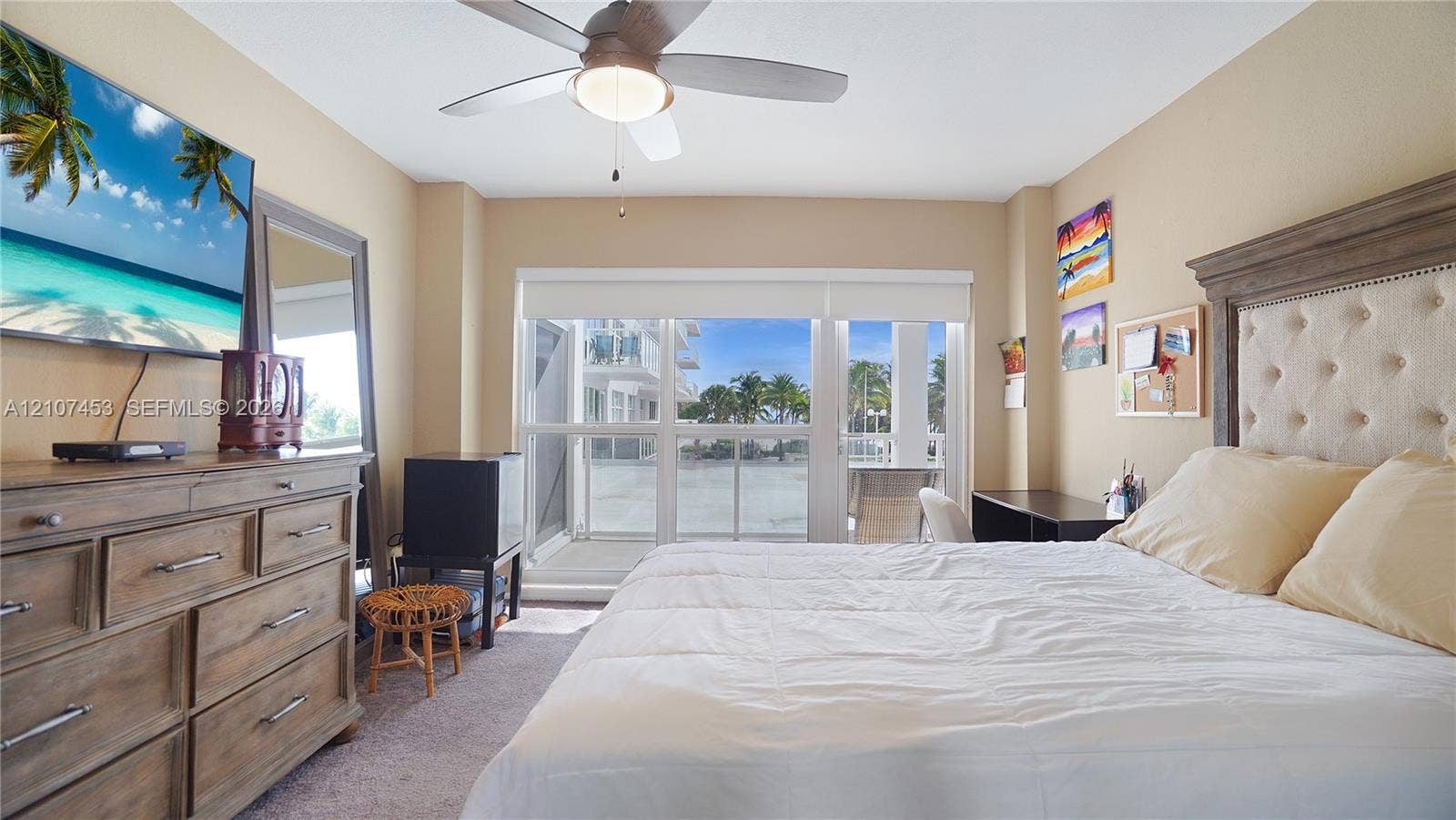 111 N Pompano Beach Boulevard, #304, Pompano Beach, FL 33062 Room featuring carpeted flooring, a ceiling fan with integrated lighting, and a glass-paneled door opening to an exterior balcony