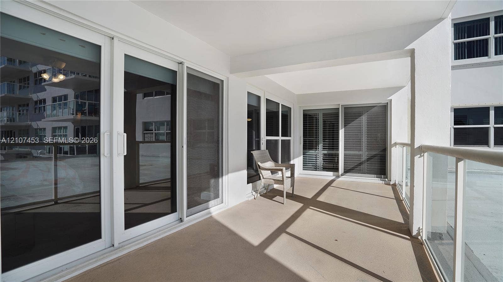 111 N Pompano Beach Boulevard, #304, Pompano Beach, FL 33062 Covered outdoor terrace featuring a concrete floor, floor-to-ceiling glass sliding doors, and a glass-paneled railing