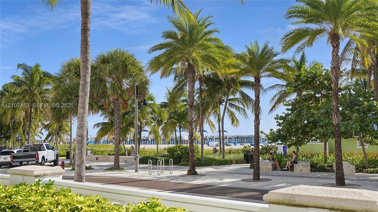 111 N Pompano Beach Boulevard, #304, Pompano Beach, FL 33062 Paved promenade featuring mature palm trees, stone-capped retaining walls, and metal bicycle racks