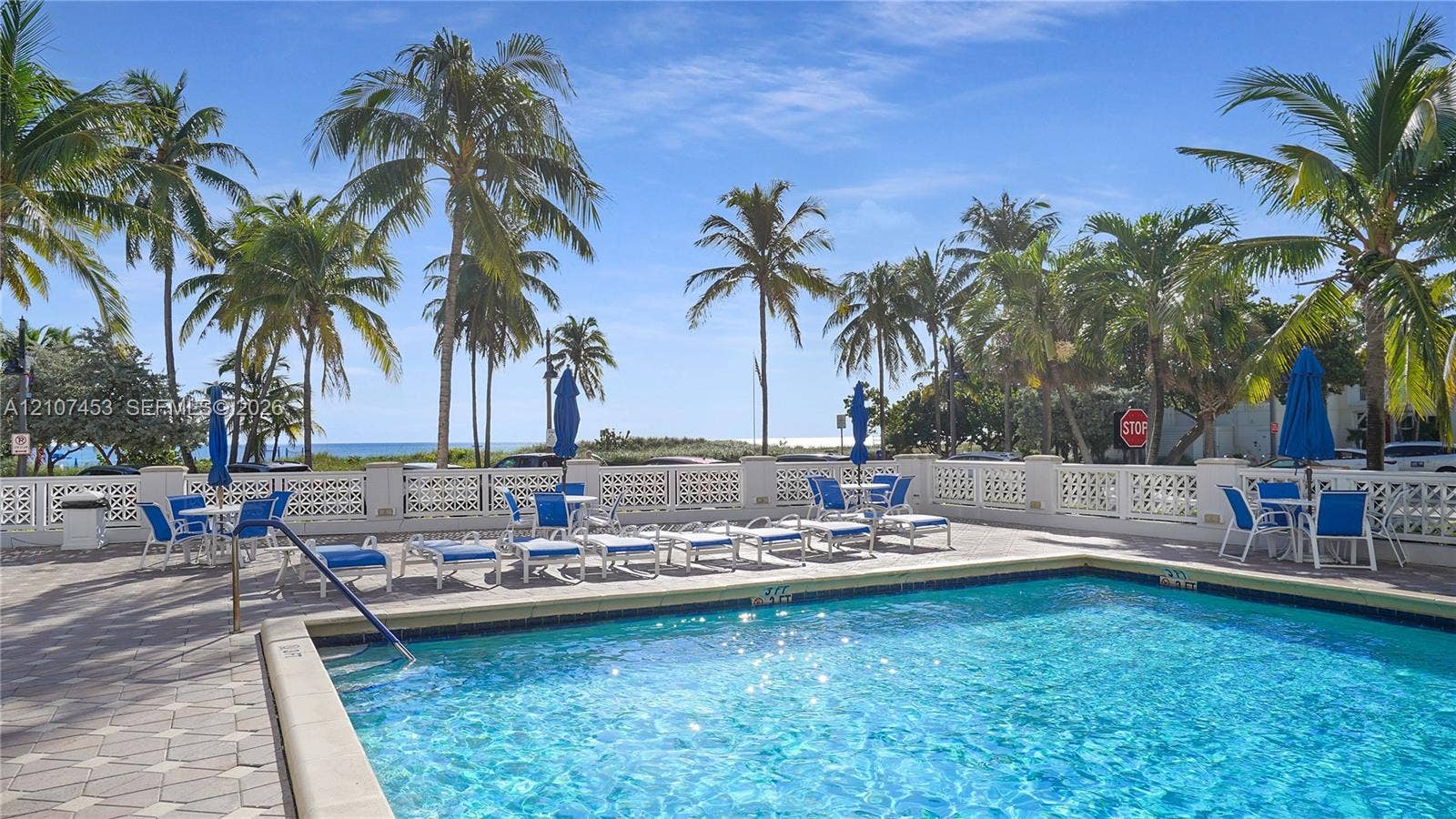 111 N Pompano Beach Boulevard, #304, Pompano Beach, FL 33062 Swimming pool with a tile surround, decorative masonry perimeter wall, and established palm trees