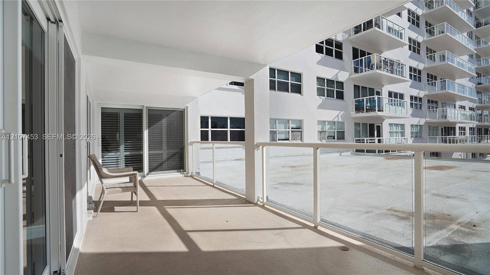 111 N Pompano Beach Boulevard, #304, Pompano Beach, FL 33062 Covered balcony featuring glass pane railings, solid-surface flooring, and sliding glass door access