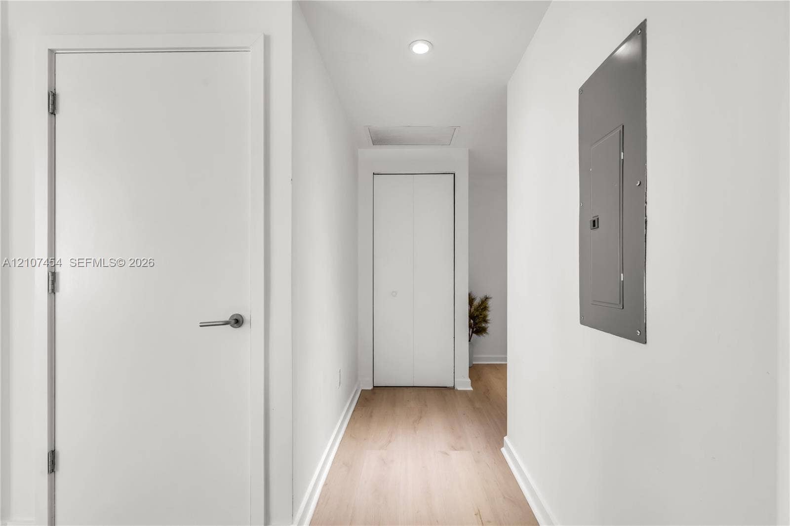 501 NE 31st Street, #1906, Miami, FL 33137 Hallway featuring light wood-finish flooring, white panel doors, recessed ceiling lighting, and a bifold closet door