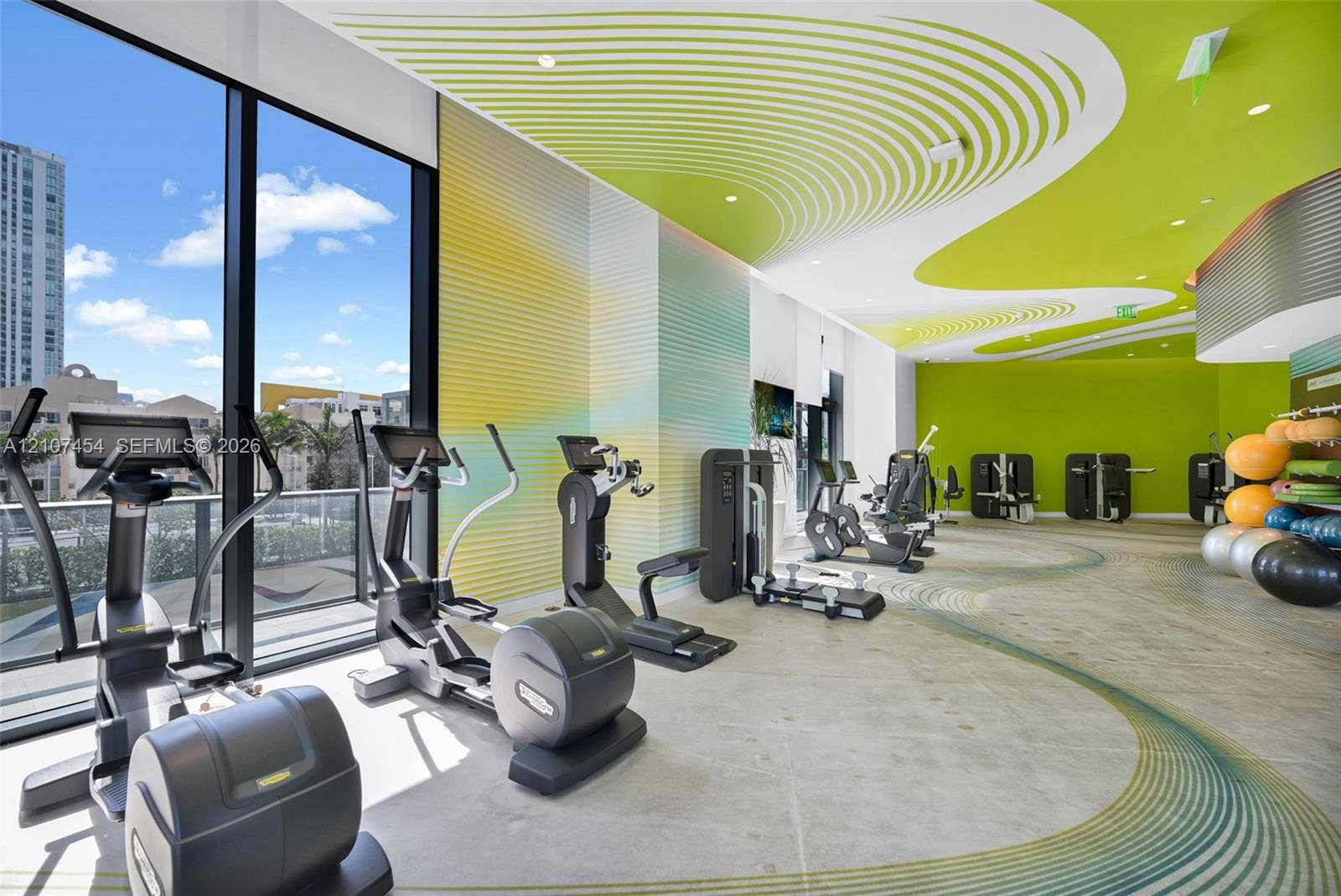 501 NE 31st Street, #1906, Miami, FL 33137 Fitness facility featuring floor-to-ceiling windows, specialized patterned ceiling treatment, corrugated wall cladding, and recessed lighting
