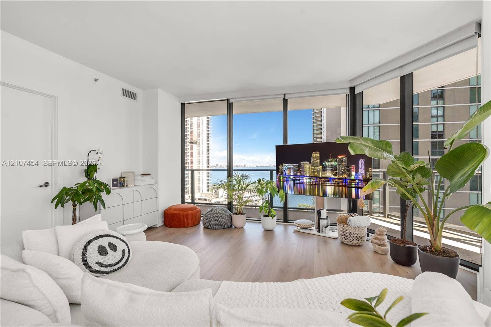 501 NE 31st Street, #1906, Miami, FL 33137 Floor-to-ceiling windows, wood-finish flooring, and an attached balcony with metal railing