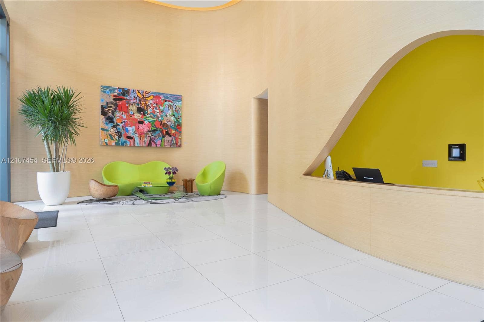 501 NE 31st Street, #1906, Miami, FL 33137 Double-height curved wall with wood-veneer finish, polished tile flooring, and a triangular architectural cutout featuring a built-in counter