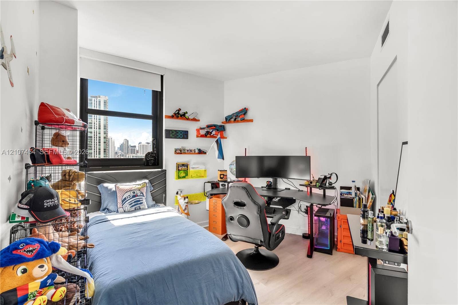501 NE 31st Street, #1906, Miami, FL 33137 Bedroom featuring light-tone wood-finish flooring, a large window with black framing, and neutral wall paint