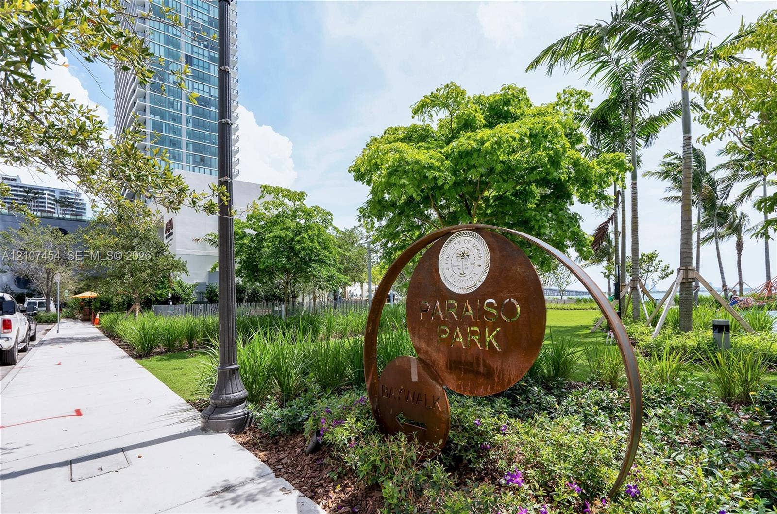 501 NE 31st Street, #1906, Miami, FL 33137 Public park space featuring landscaped greenery, mature trees, palm trees, and paved walkways
