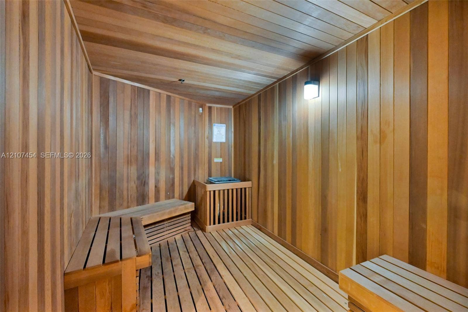501 NE 31st Street, #1906, Miami, FL 33137 Sauna featuring wood-plank wall paneling, slatted wood-finish flooring, tiered built-in wood bench seating, and integrated wall lighting
