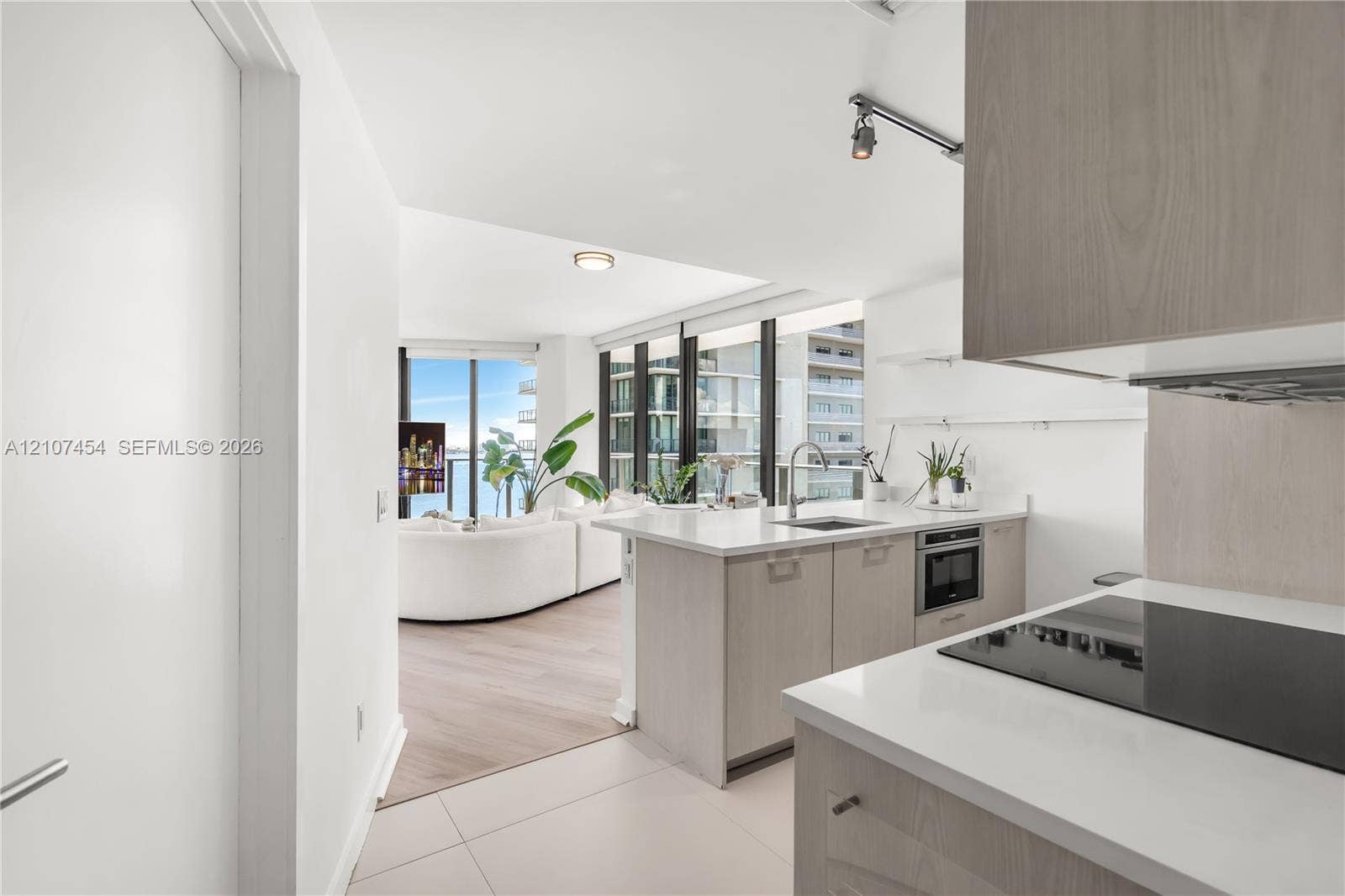501 NE 31st Street, #1906, Miami, FL 33137 Kitchen featuring light wood-finish cabinetry, white countertops, built-in cooktop, and floor-to-ceiling windows