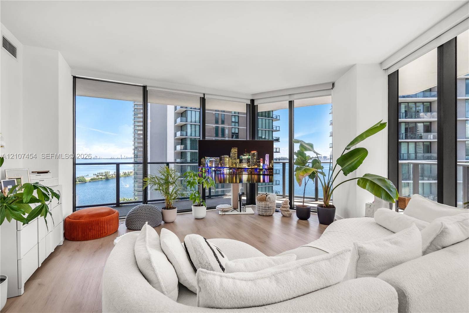 501 NE 31st Street, #1906, Miami, FL 33137 Floor-to-ceiling windows, wood-finish flooring, and black metal-framed balcony access with a glass railing