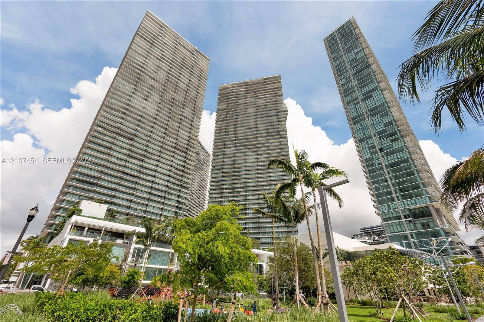501 NE 31st Street, #1906, Miami, FL 33137 High-rise residential towers featuring glass-paneled facades, private balconies, and integrated landscaping with mature palm trees