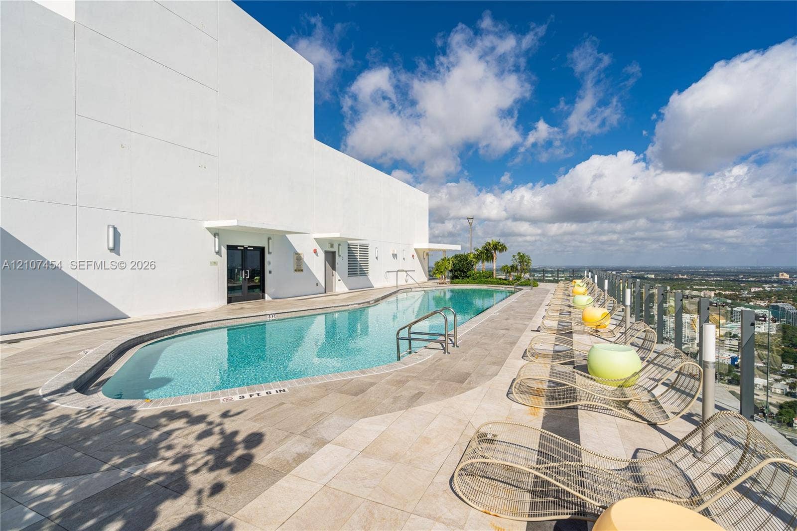 501 NE 31st Street, #1906, Miami, FL 33137 Rooftop swimming pool featuring stone tile decking, perimeter glass railing, and metal handrails