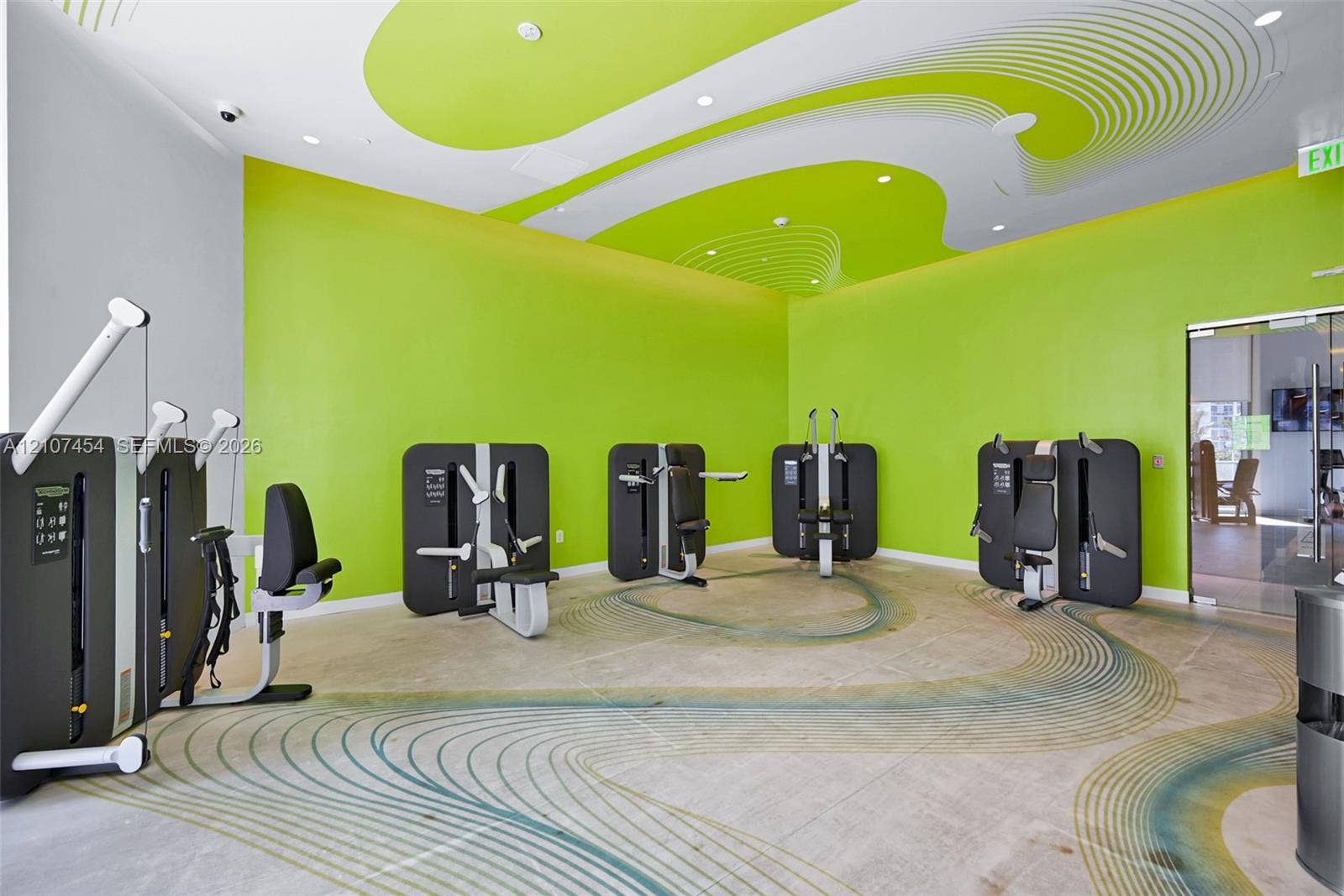 501 NE 31st Street, #1906, Miami, FL 33137 Fitness center featuring polished concrete flooring with a decorative inlay pattern, high ceilings with stylized graphic accents, and recessed lighting