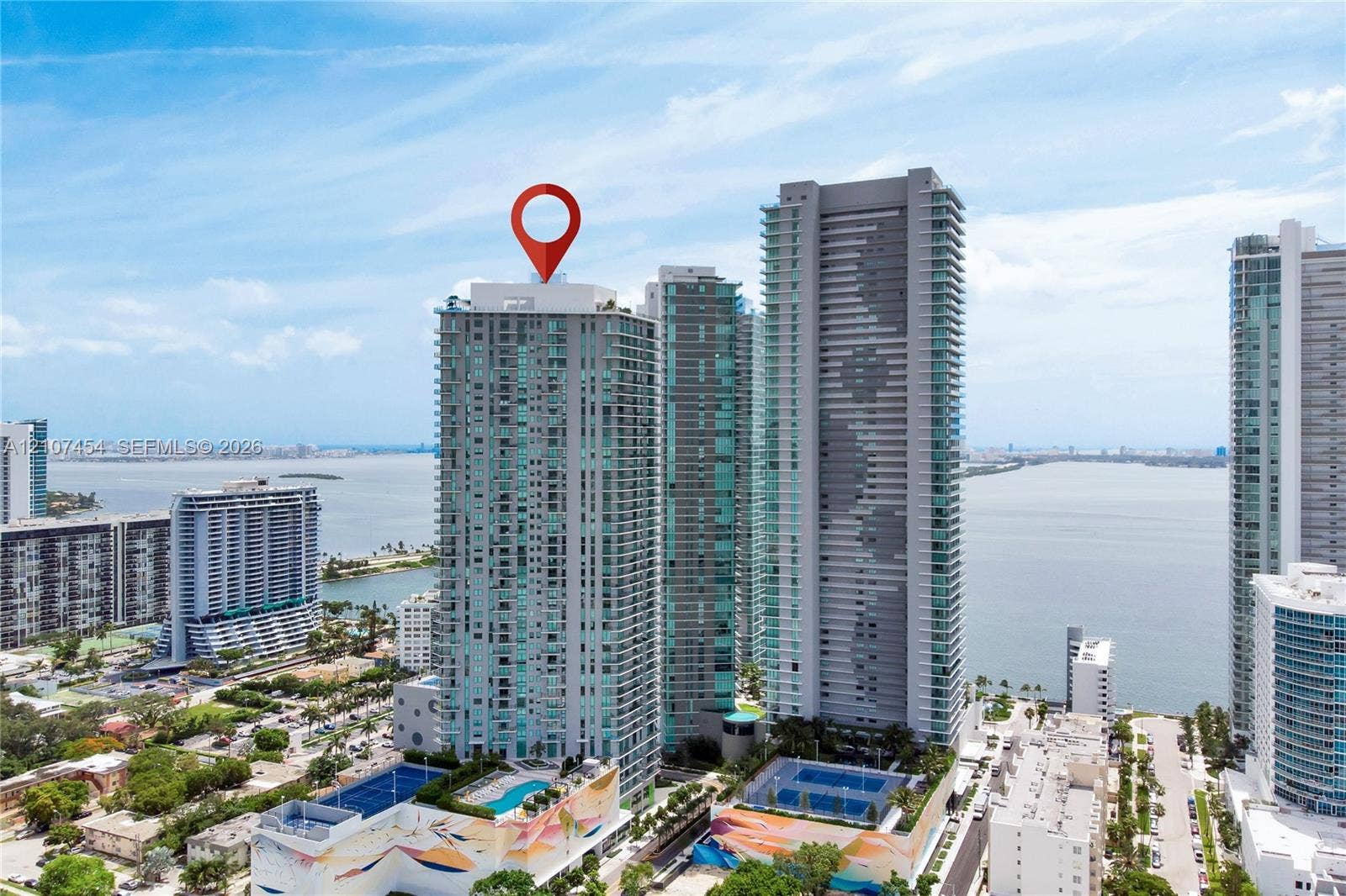 501 NE 31st Street, #1906, Miami, FL 33137 High-rise residential tower featuring glass-facade architecture, podium-level swimming pool, and dedicated court facilities