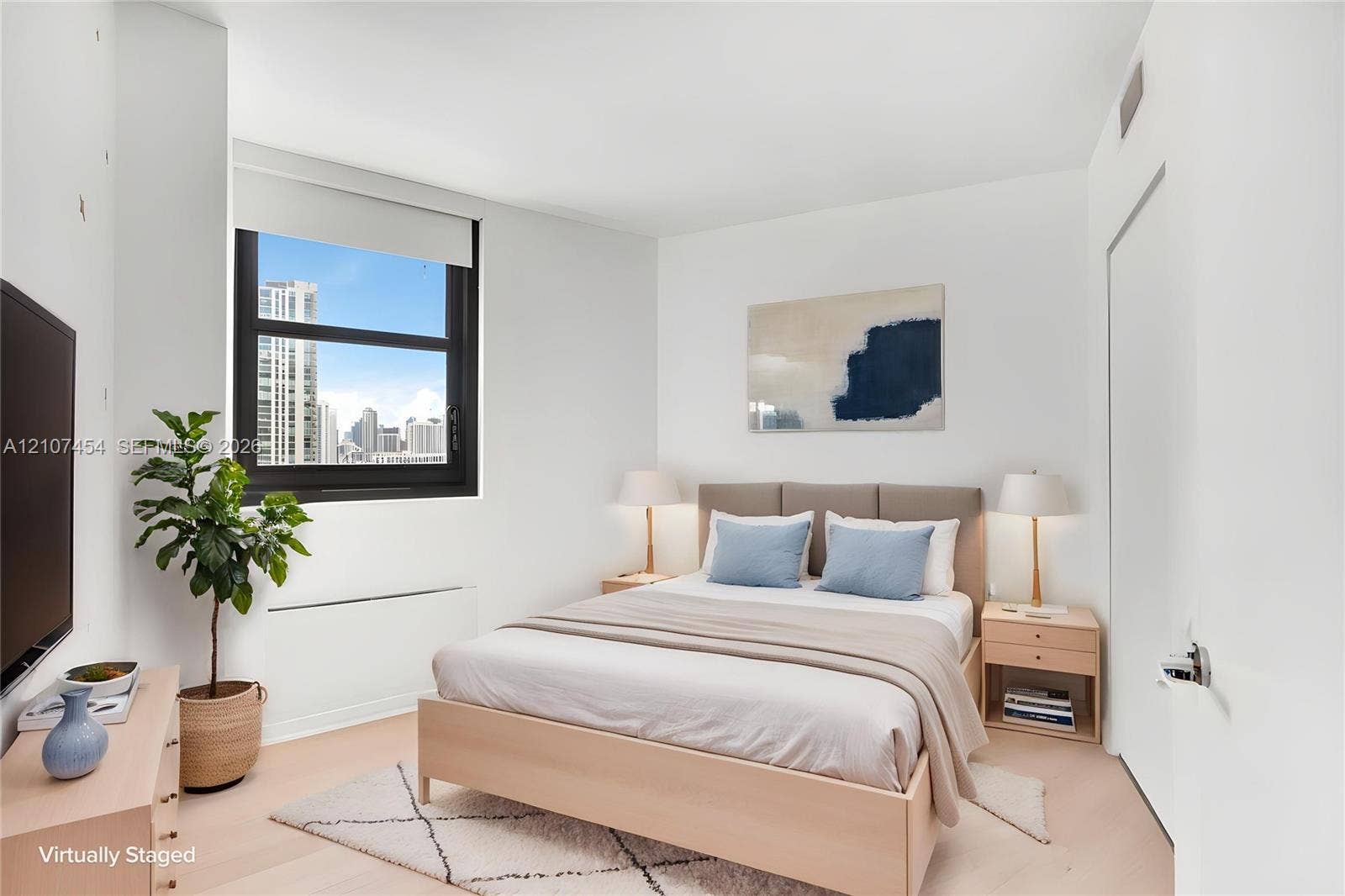 501 NE 31st Street, #1906, Miami, FL 33137 Neutral-toned interior featuring wood-finish flooring, a large window with black framing, and a urban skyline backdrop