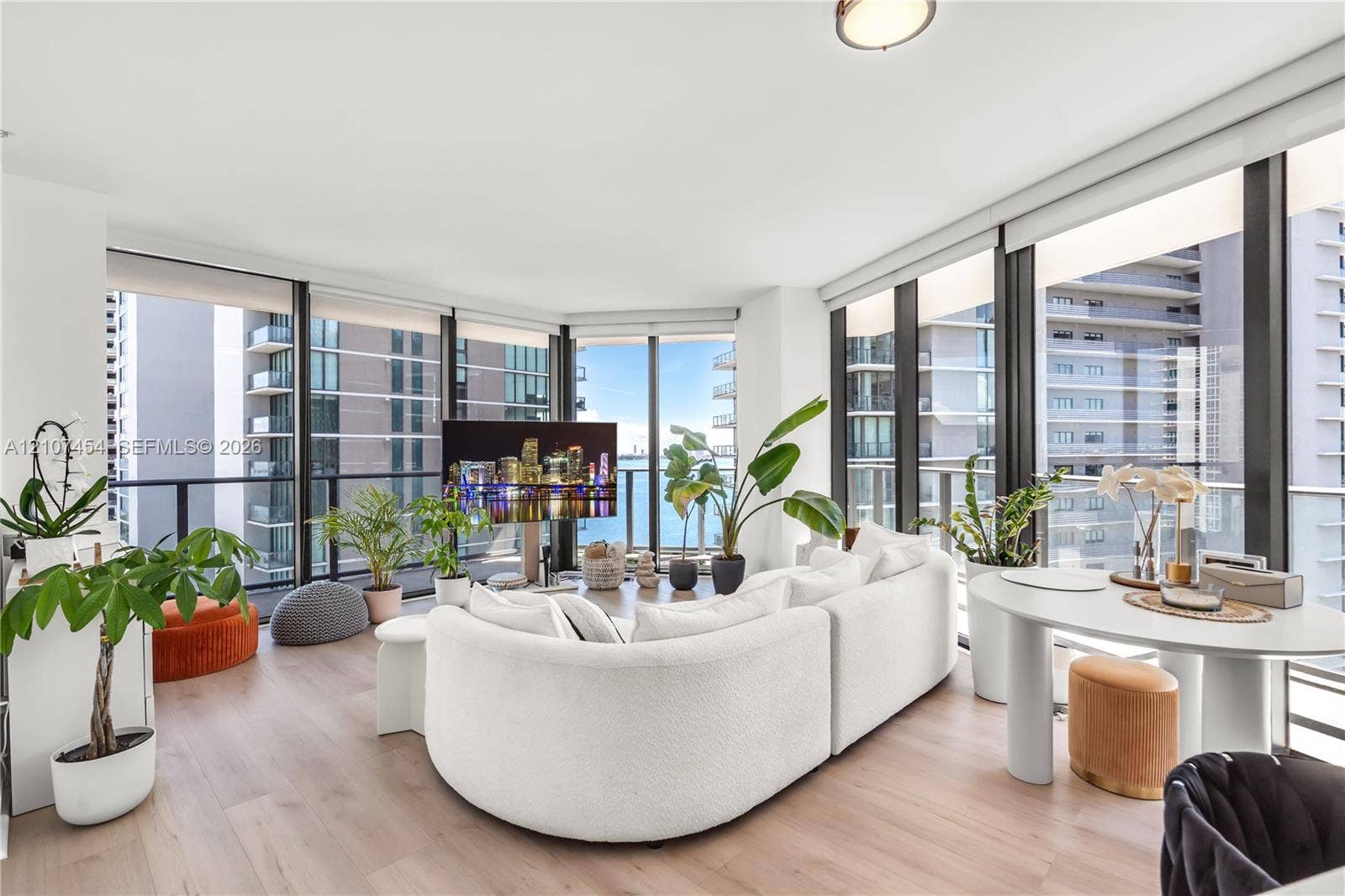 501 NE 31st Street, #1906, Miami, FL 33137 Floor-to-ceiling windows, wood-finish flooring, and wraparound glass balcony railings