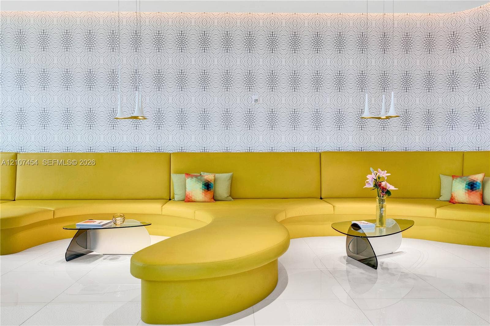 501 NE 31st Street, #1906, Miami, FL 33137 Built-in curved yellow seating, geometric patterned wallpaper, polished tile flooring, and dual hanging pendant lights with gold-tone accents