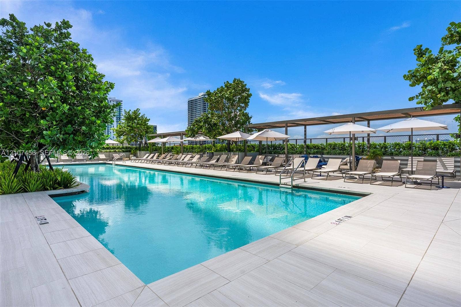 1400 Biscayne Boulevard, #2604, Miami, Miami, FL 33132 Rectangular swimming pool featuring light-toned tile decking, a metal pergola structure, and landscaped greenery