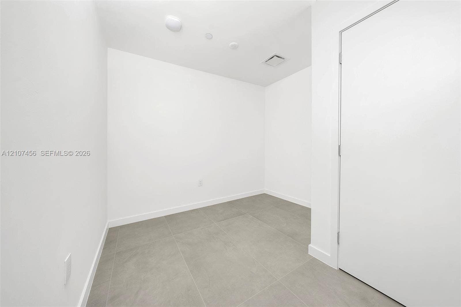 1400 Biscayne Boulevard, #2604, Miami, Miami, FL 33132 Interior room featuring neutral wall paint, large-format grey tile flooring, and a single-panel interior door