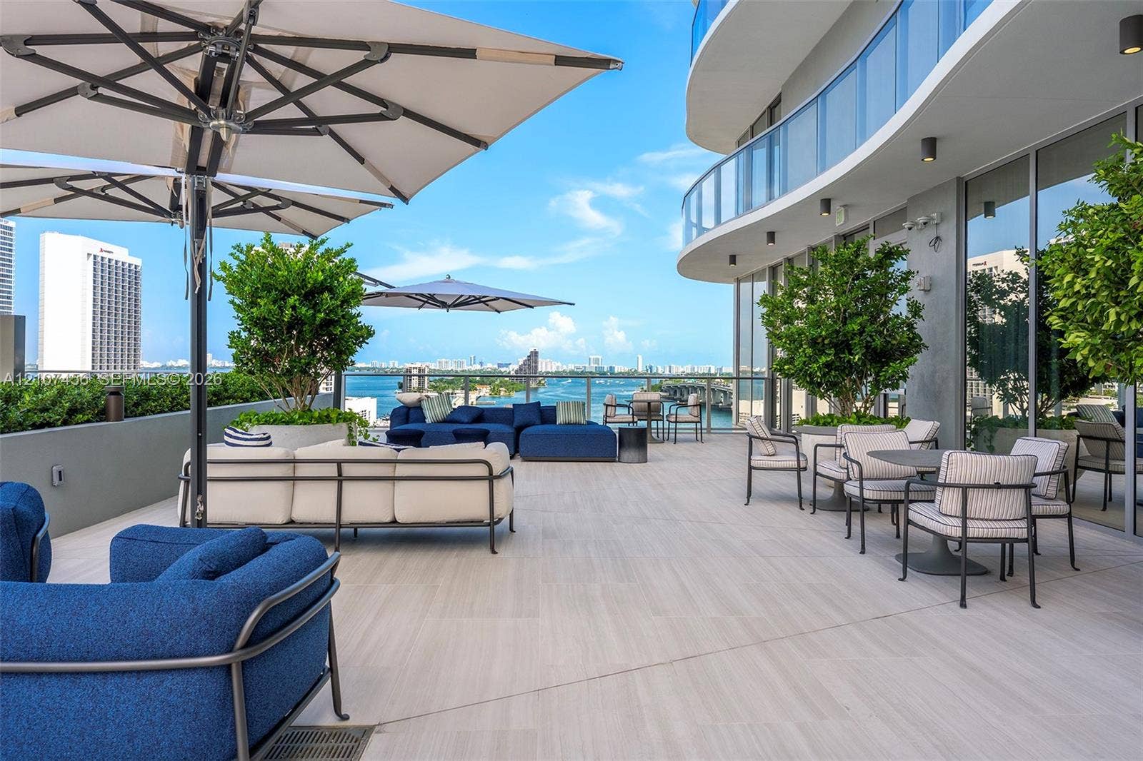 1400 Biscayne Boulevard, #2604, Miami, Miami, FL 33132 Expansive wraparound balcony featuring large-format tile flooring, a glass-panel railing, integrated wall-mounted lighting, and built-in landscape planters