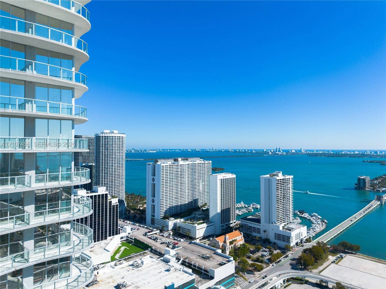 1400 Biscayne Boulevard, #2604, Miami, Miami, FL 33132 High-rise exterior featuring curved glass facade, wraparound glass-panel balconies, and floor-to-ceiling windows
