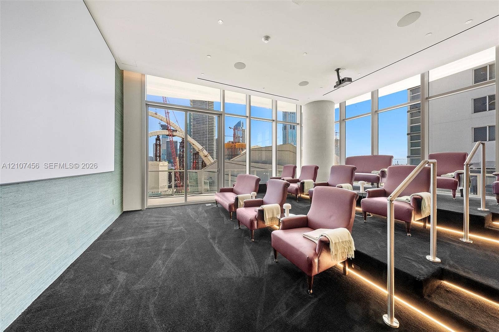 1400 Biscayne Boulevard, #2604, Miami, Miami, FL 33132 Media room featuring tiered flooring with integrated LED lighting, floor-to-ceiling windows, wall-mounted projection screen, and ceiling-mounted projector