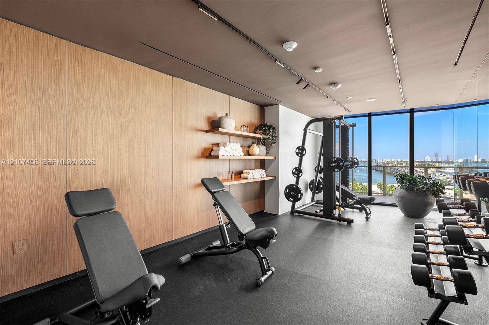 1400 Biscayne Boulevard, #2604, Miami, Miami, FL 33132 Floor-to-ceiling windows, wood-panelled accent wall, built-in open shelving, track lighting, and rubberized flooring
