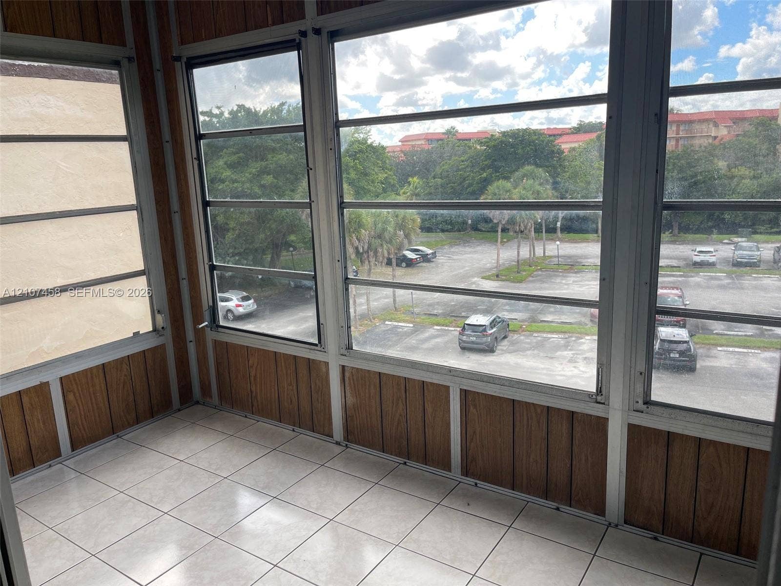 7300 NW 17th Street, #421, Plantation, Plantation, FL 33313 Enclosed porch featuring wood-finish paneling, horizontal sliding windows, and tiled flooring