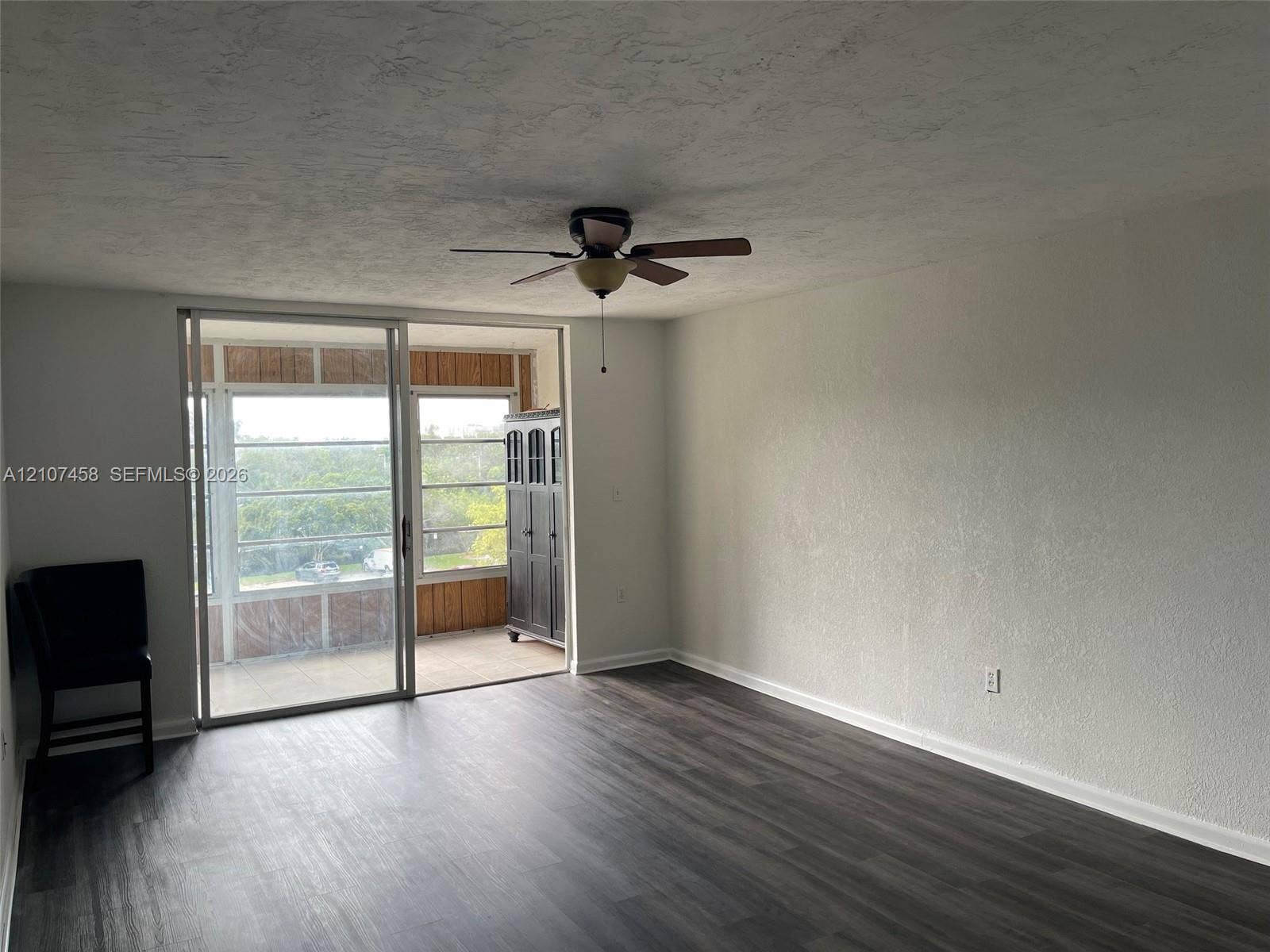 7300 NW 17th Street, #421, Plantation, Plantation, FL 33313 Living area featuring wood-finish flooring, a ceiling fan with integrated lighting, and glass sliding doors