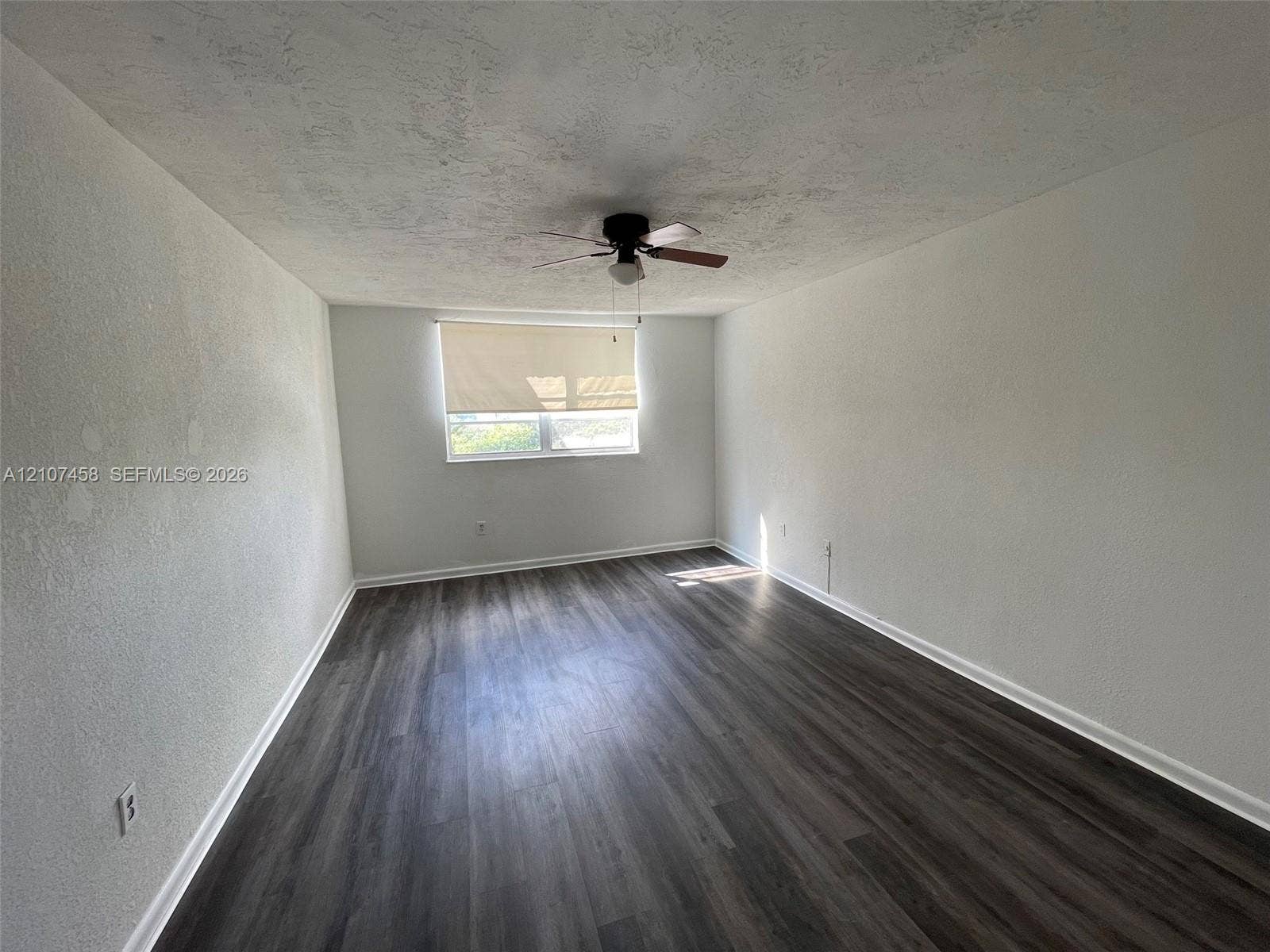 7300 NW 17th Street, #421, Plantation, Plantation, FL 33313 Interior space featuring wood-finish flooring, a neutral color palette, and a central ceiling fan with an integrated light fixture