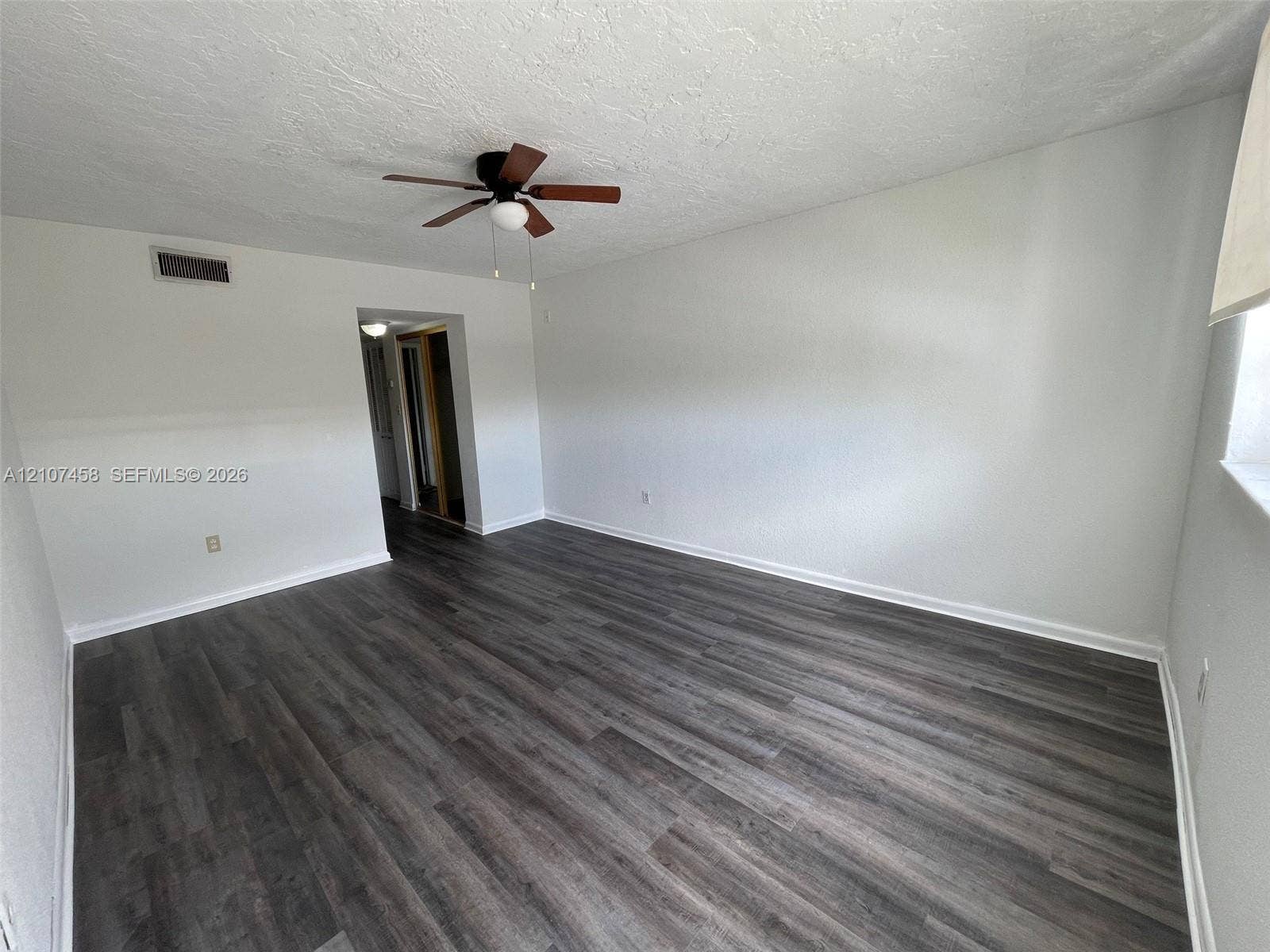 7300 NW 17th Street, #421, Plantation, Plantation, FL 33313 Interior space featuring wood-finish flooring, white walls, and a ceiling-mounted fan with integrated lighting