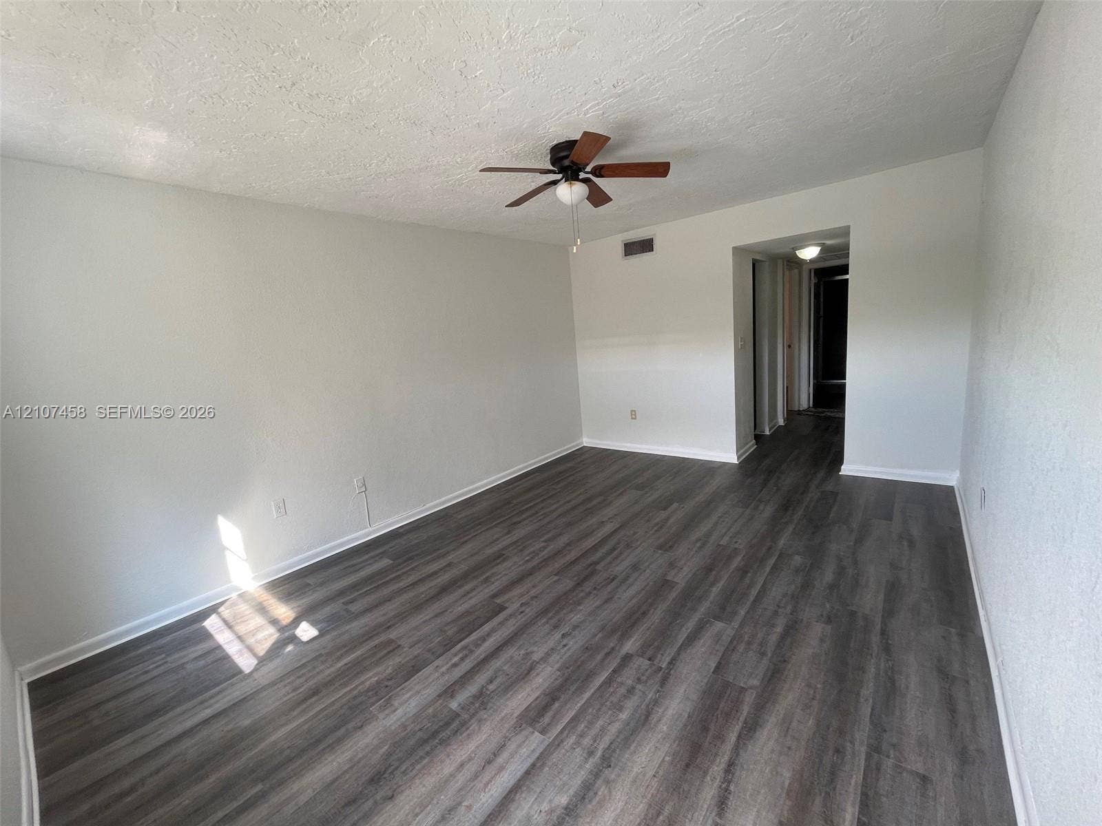 7300 NW 17th Street, #421, Plantation, Plantation, FL 33313 Room featuring wood-finish flooring, textured ceiling, and a central ceiling fan with integrated lighting