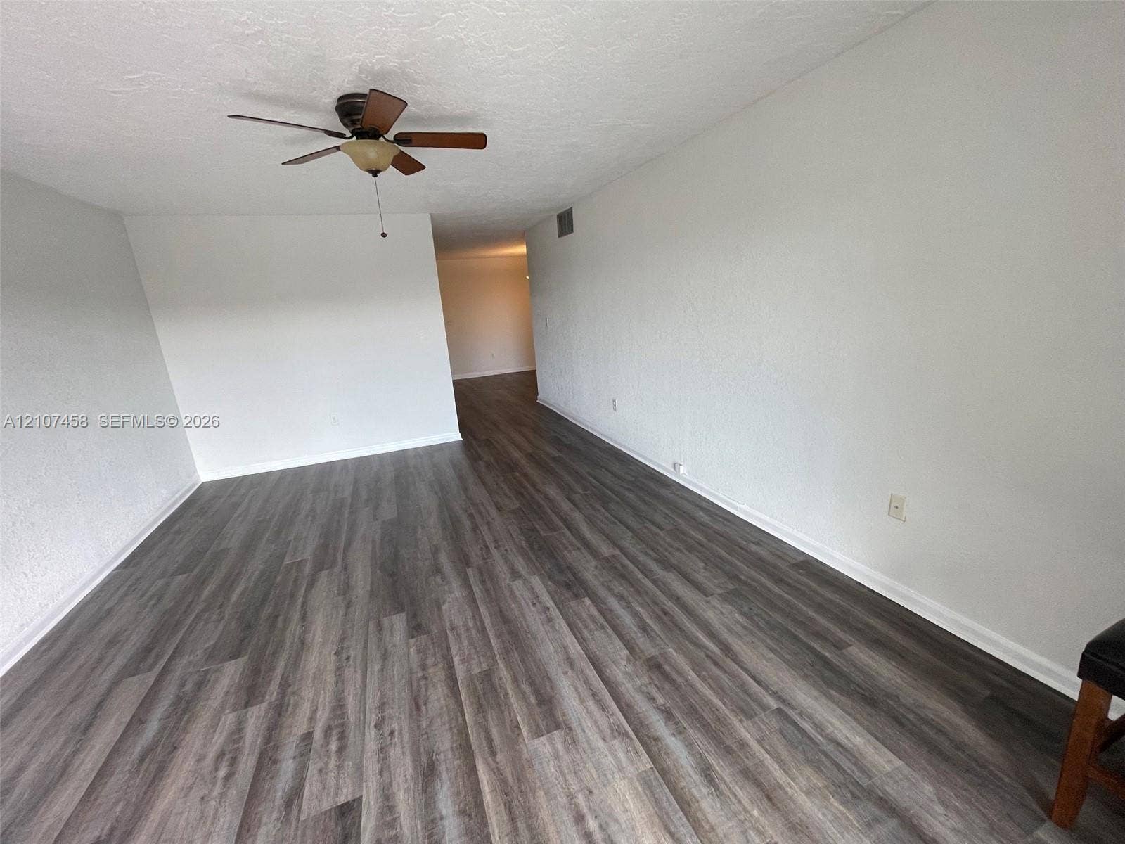 7300 NW 17th Street, #421, Plantation, Plantation, FL 33313 Interior space featuring wood-finish flooring, white walls, and a ceiling-mounted fan with integrated light fixture