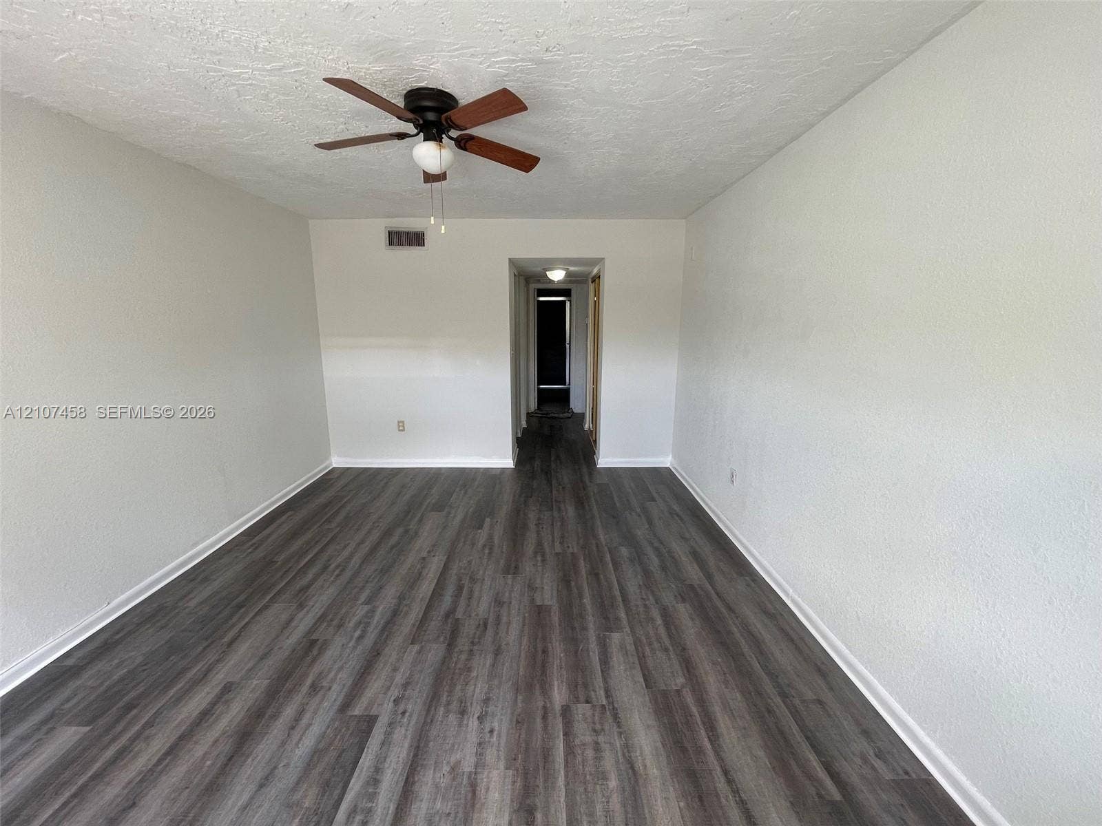 7300 NW 17th Street, #421, Plantation, Plantation, FL 33313 Interior space featuring wood-finish flooring, textured ceilings, and a ceiling fan with light fixture