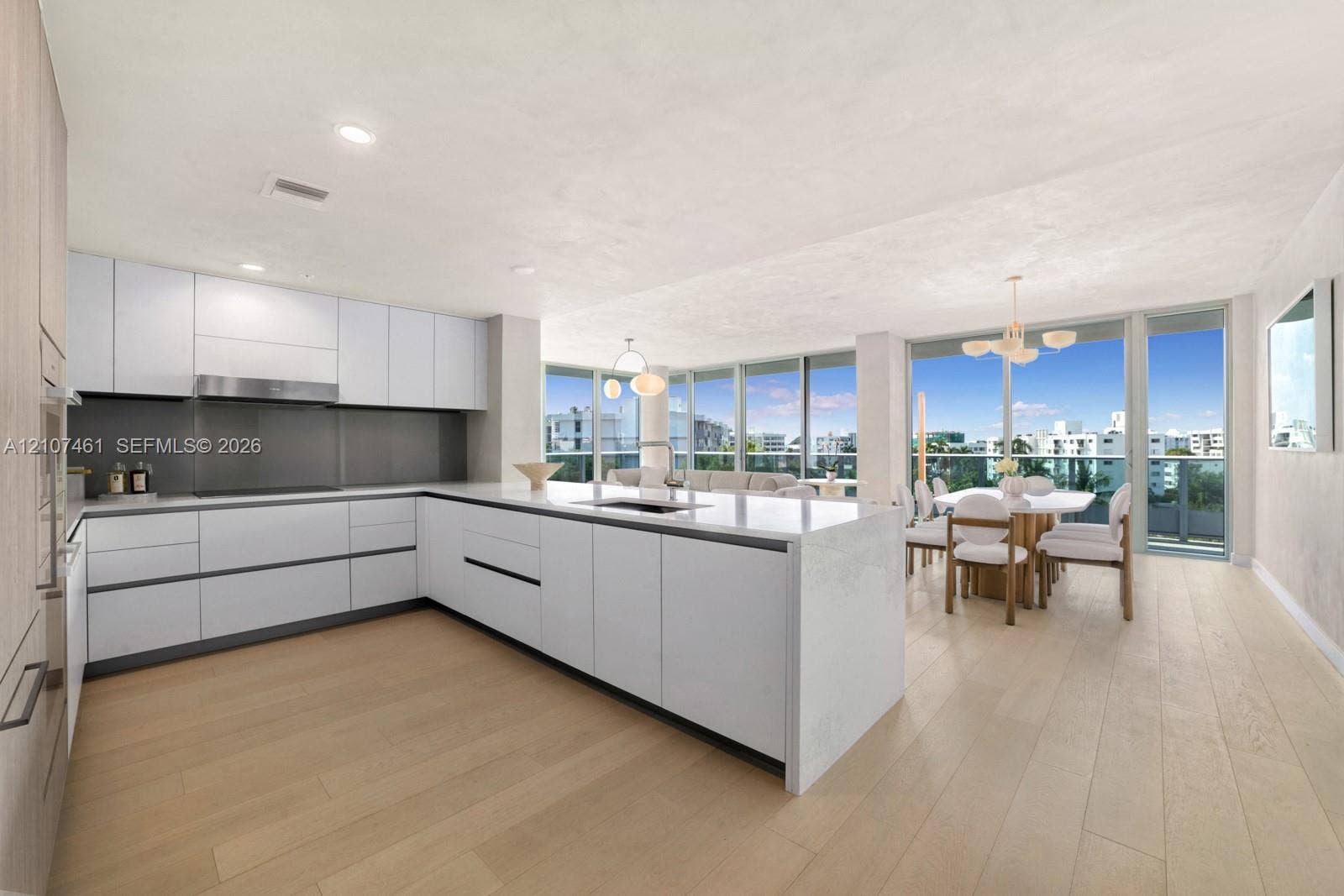 9201 E Bay Harbor Drive, #602, Bal Harbour, FL 33141 Contemporary kitchen featuring flat-panel cabinetry, a central island with a solid-surface countertop, recessed lighting, and expansive floor-to-ceiling windows