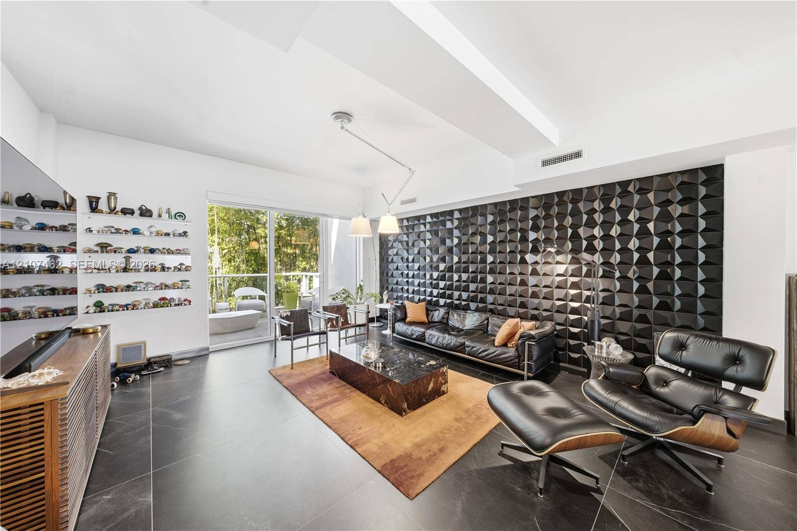 455 NE 39th Street, #110, Miami, FL 33137 Living area featuring a three-dimensional geometric accent wall, oversized tile flooring, recessed lighting, and sliding glass doors to the exterior