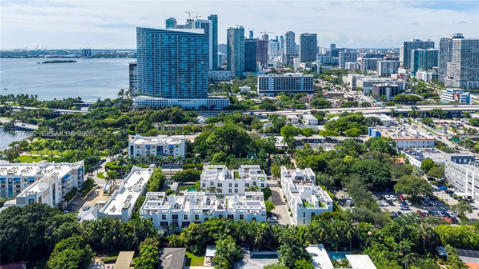 455 NE 39th Street, #110, Miami, FL 33137 Aerial perspective featuring low-rise multi-unit residential structures, flat roofing systems, and lush surrounding canopy