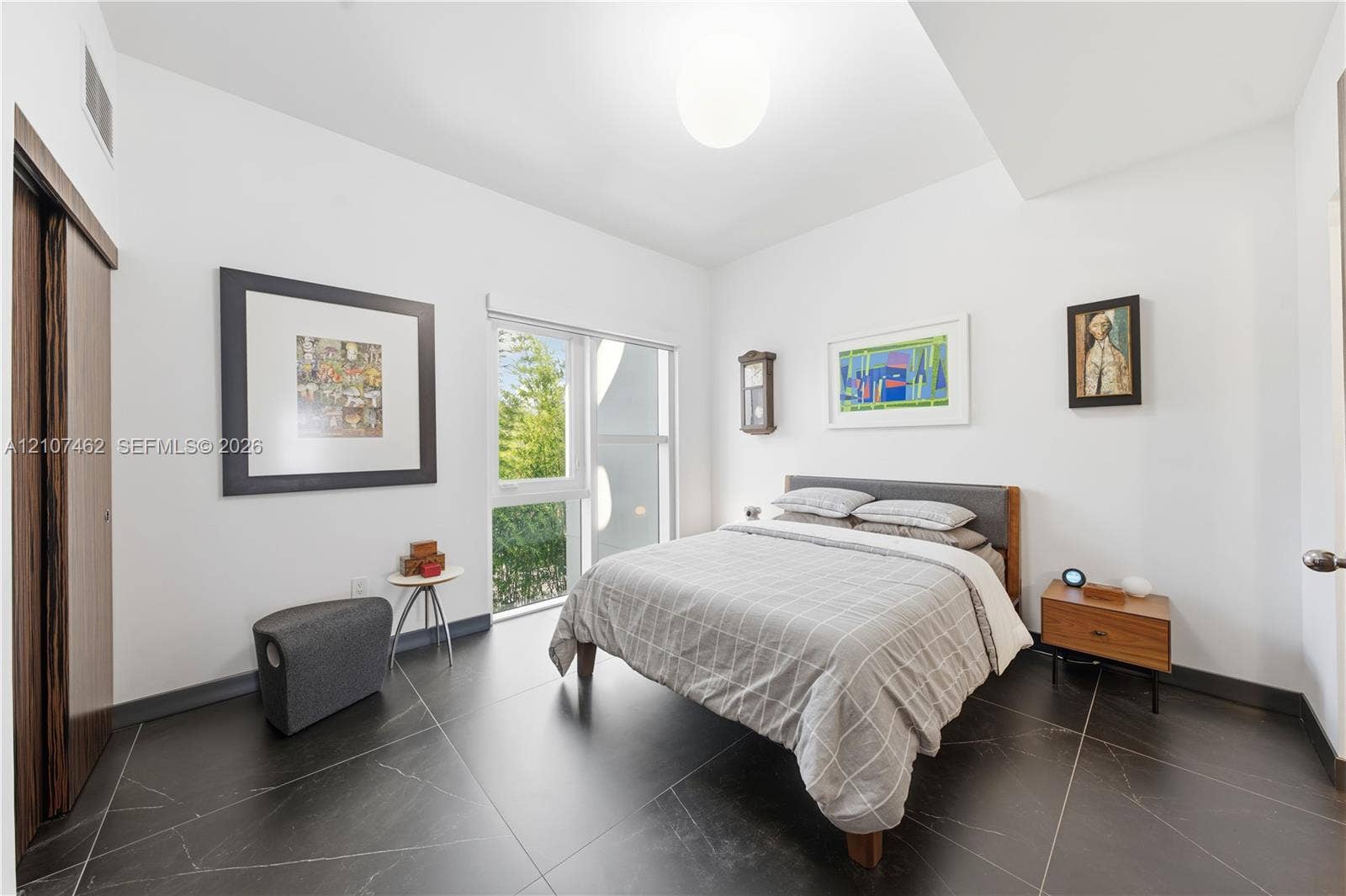 455 NE 39th Street, #110, Miami, FL 33137 Large-format tile flooring, oversized window with natural light, high ceilings, and wood-finish sliding closet doors