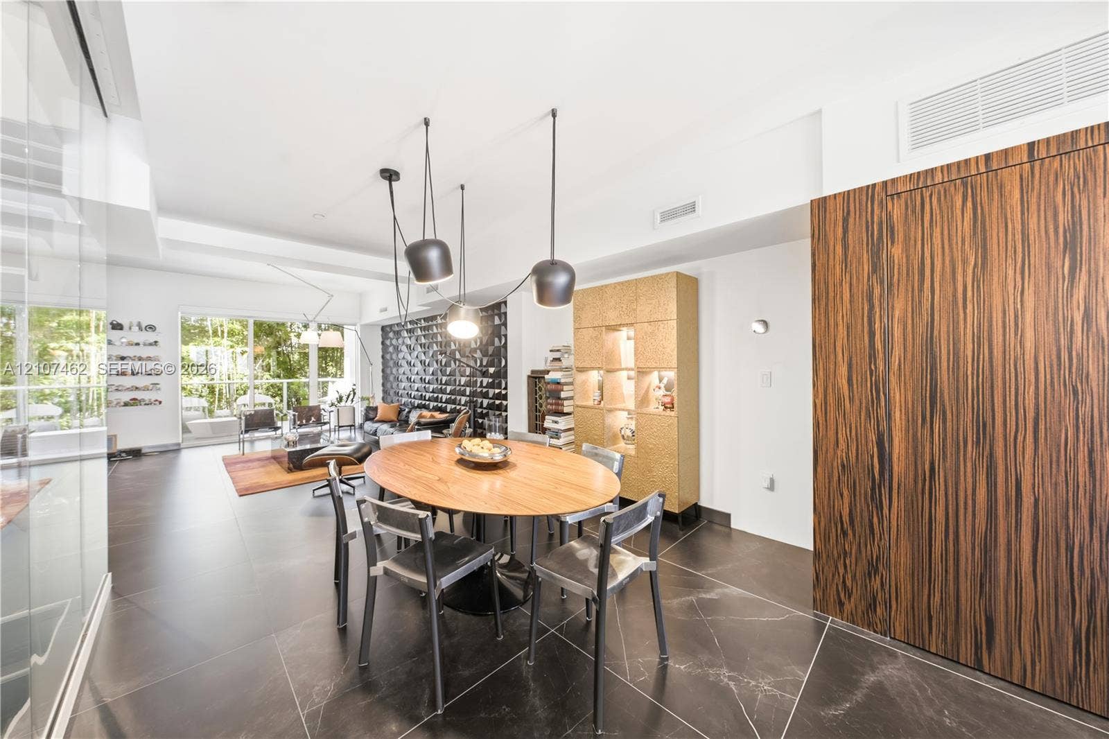 455 NE 39th Street, #110, Miami, FL 33137 Large-format tile flooring, wood-grain paneling, custom built-in display cabinetry, and contemporary multi-pendant lighting