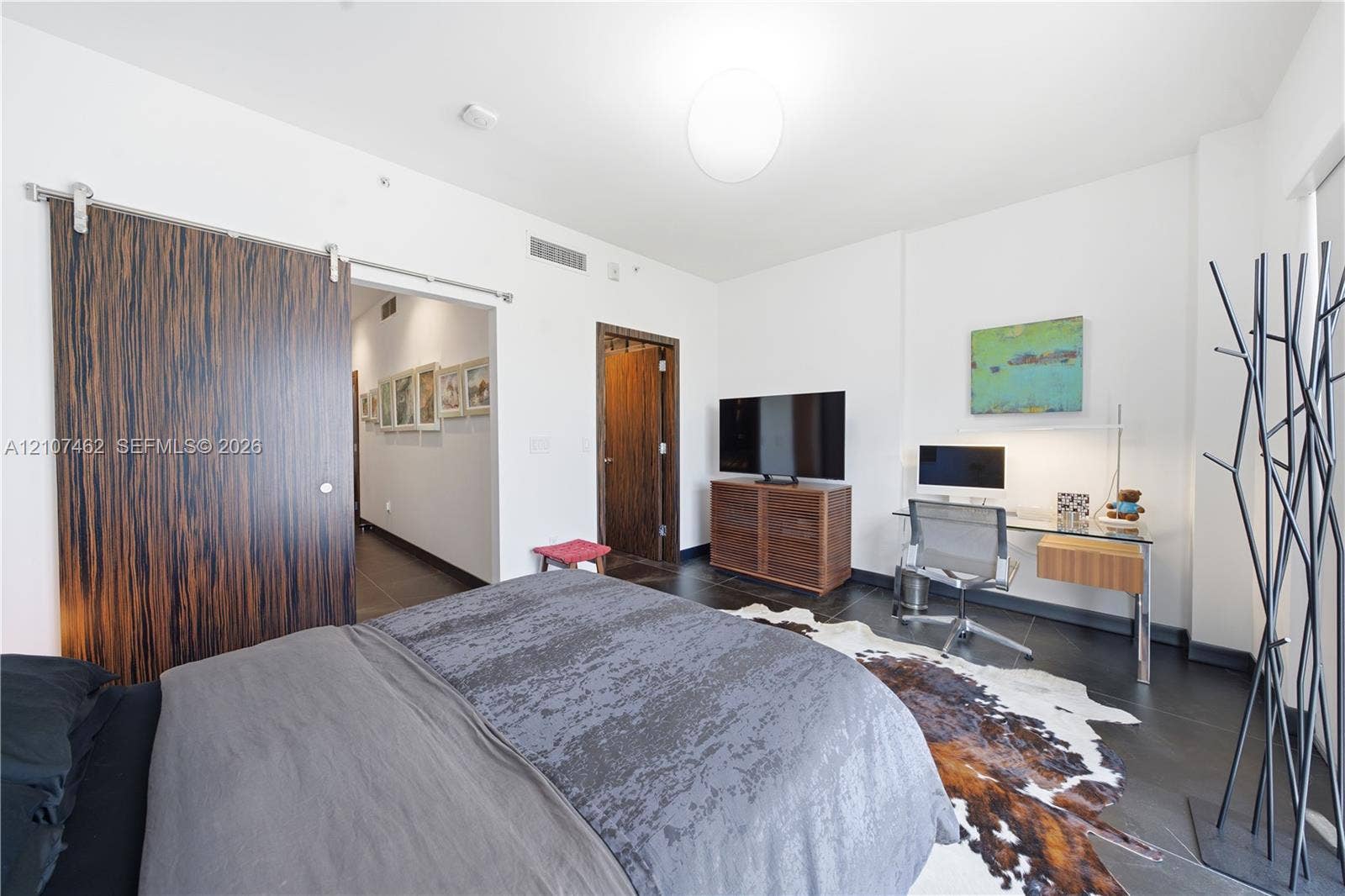 455 NE 39th Street, #110, Miami, FL 33137 Interior space featuring dark tile flooring, a large wood-finish sliding barn door, and a standard swinging door with wood-finish trim