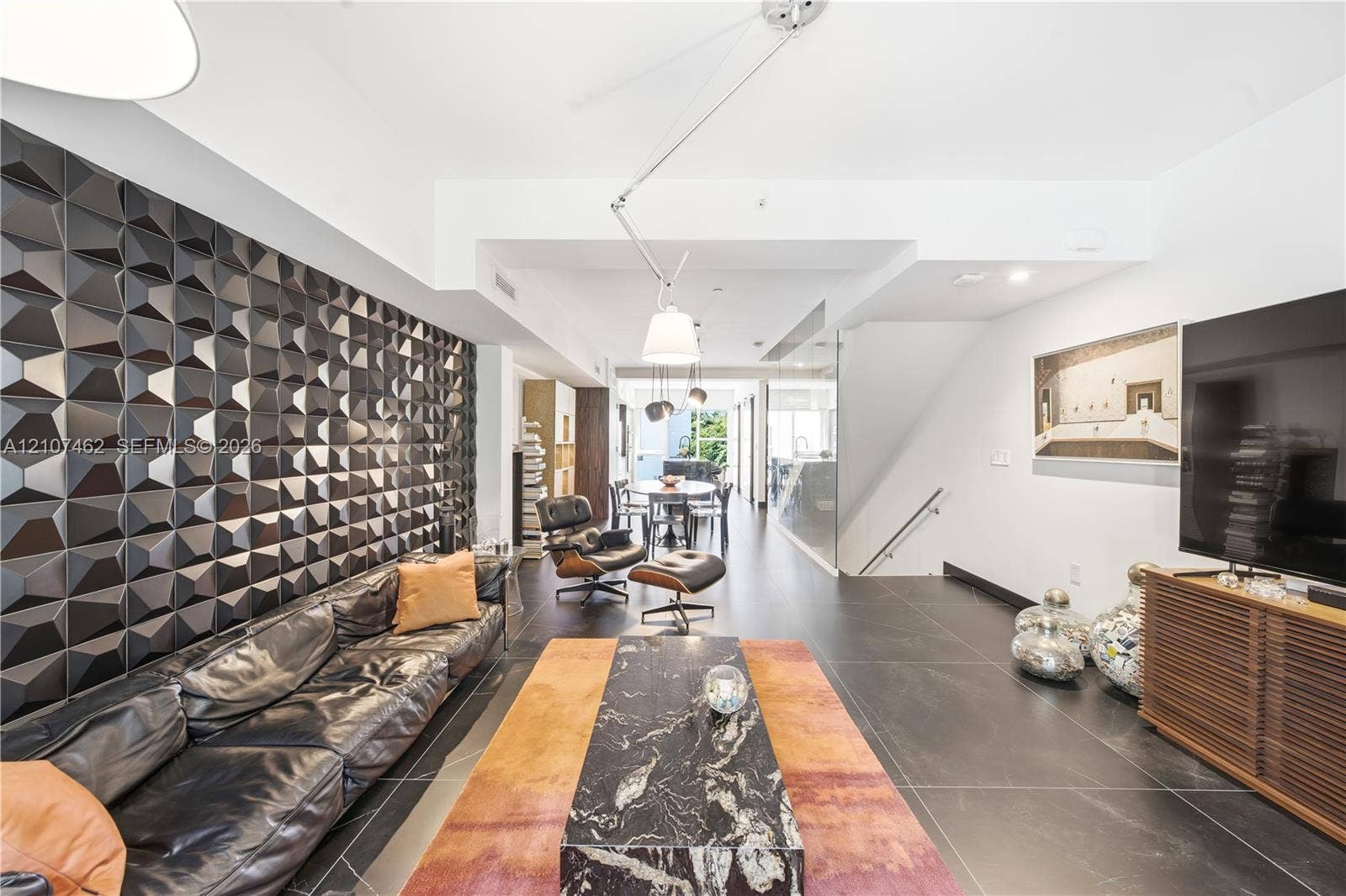 455 NE 39th Street, #110, Miami, FL 33137 Geometric three-dimensional feature wall, large-format tile flooring, adjustable multi-arm pendant lighting, and recessed ceiling lighting