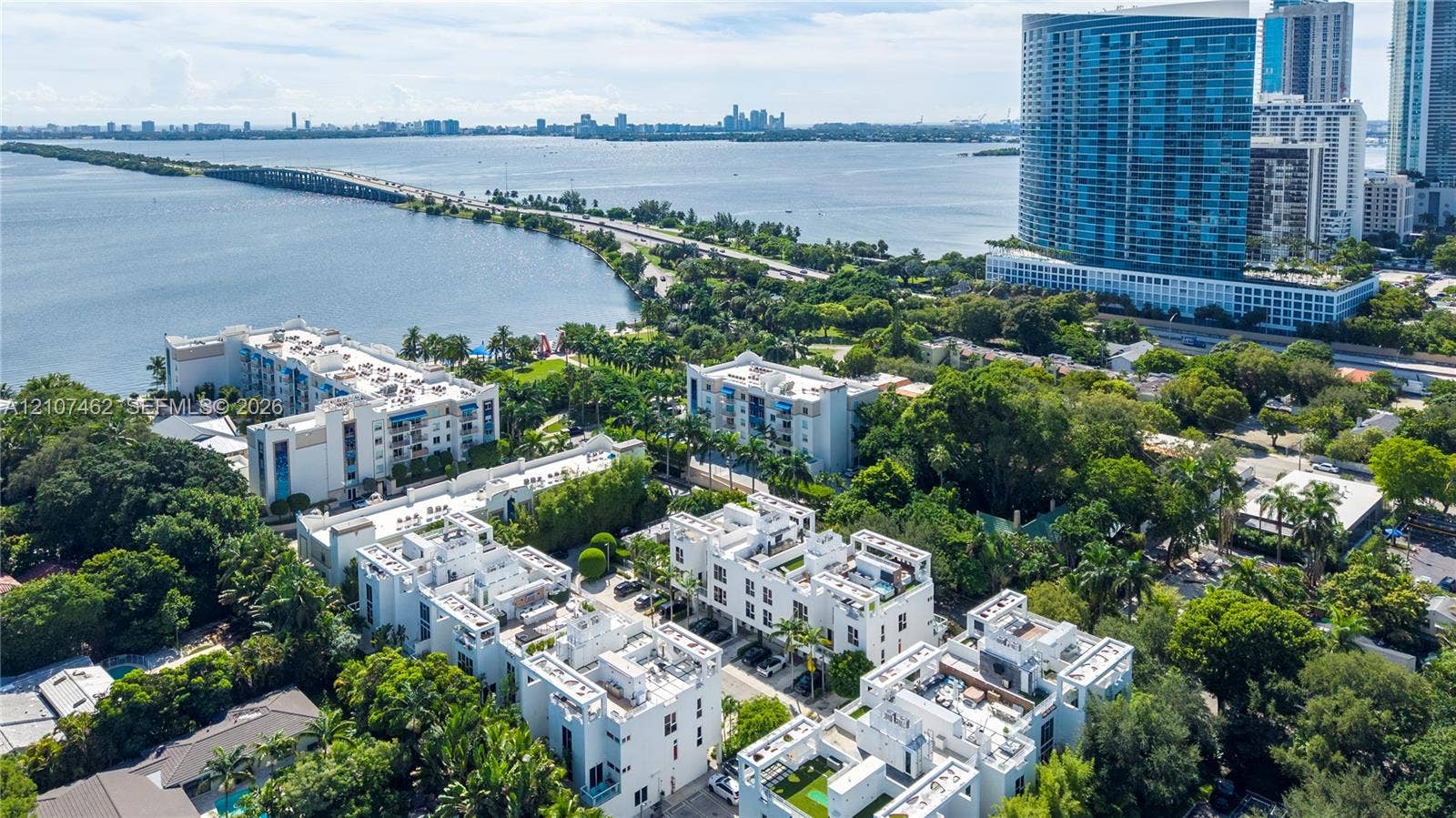 455 NE 39th Street, #110, Miami, FL 33137 Aerial perspective of multi-level residential complex featuring white stucco facades, flat rooflines, rooftop terraces, and established tropical landscaping