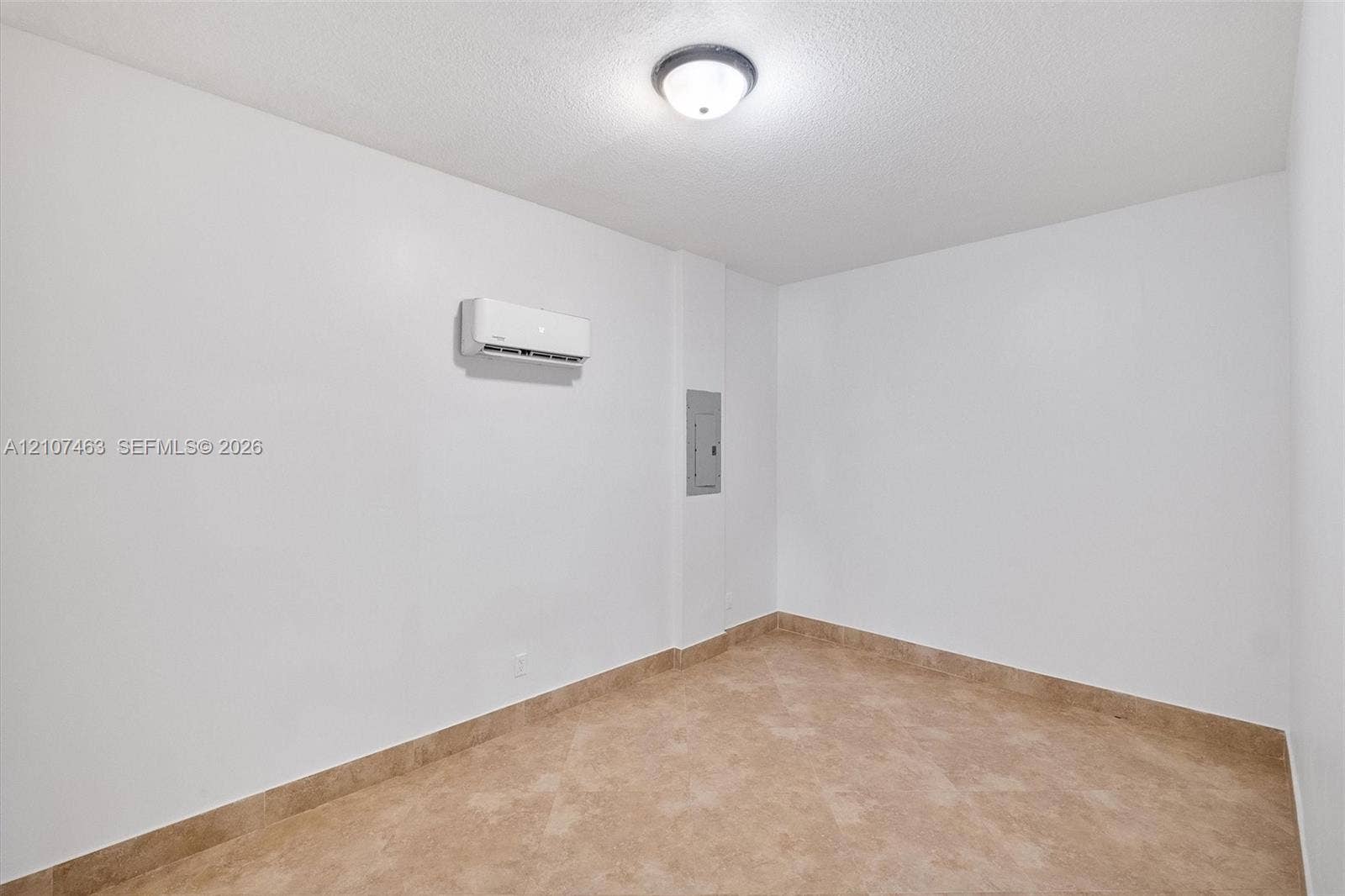 7071 W 6th Avenue, #N/A, Hialeah, Hialeah, FL 33014 Room 3 featuring tile flooring, a wall-mounted ductless air conditioning unit, and a flush-mount ceiling light fixture