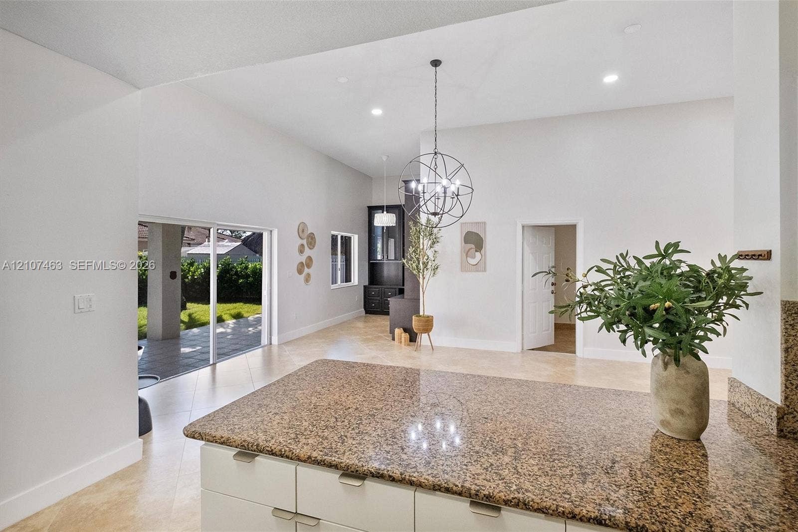 7071 W 6th Avenue, #N/A, Hialeah, Hialeah, FL 33014 Open-concept kitchen and living area featuring high vaulted ceilings, stone-finish countertops, tile flooring, recessed lighting, and a spherical metal chandelier
