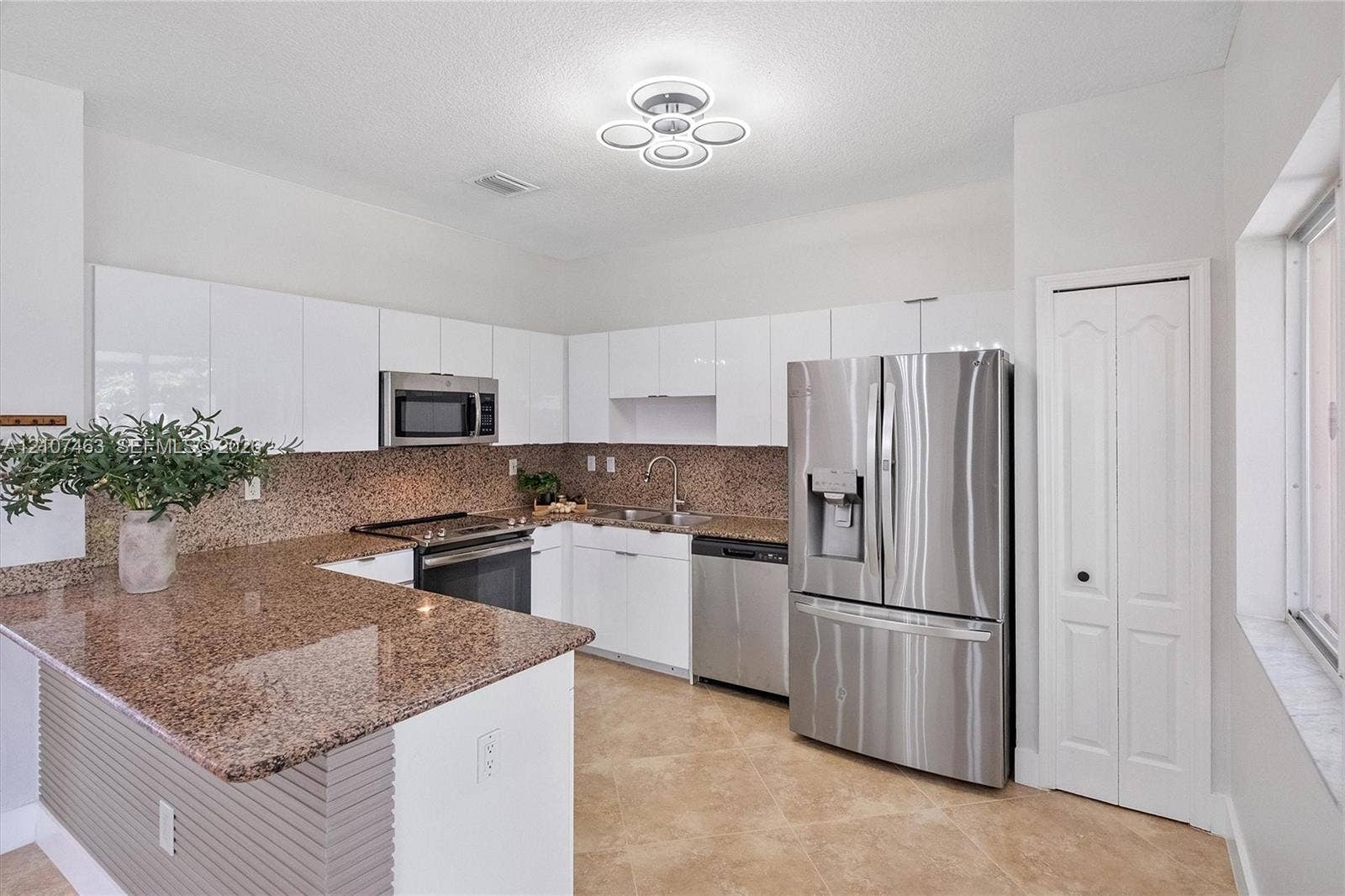 7071 W 6th Avenue, #N/A, Hialeah, Hialeah, FL 33014 Kitchen featuring white high-gloss cabinetry, stone countertops, stainless steel appliances, tile flooring, and a modern circular ceiling fixture