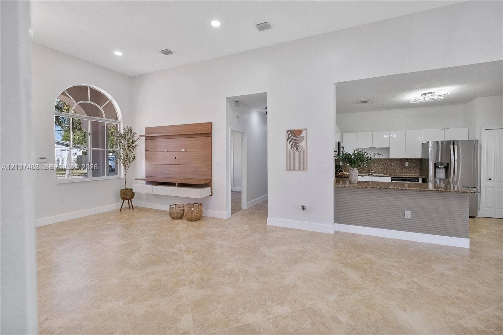 7071 W 6th Avenue, #N/A, Hialeah, Hialeah, FL 33014 Open-concept living space featuring high ceilings, recessed lighting, tile flooring, an arched window, and a built-in media console