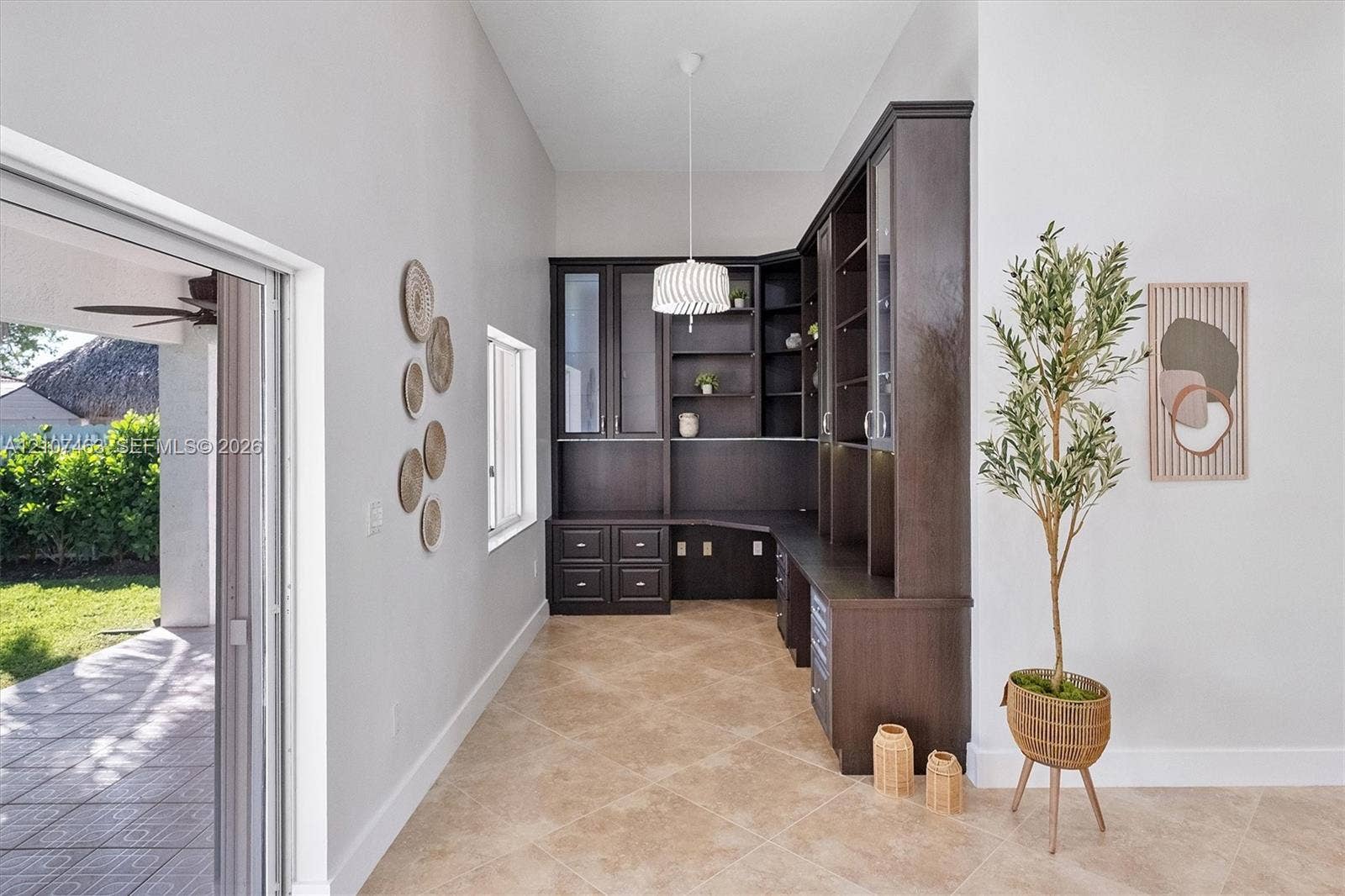 7071 W 6th Avenue, #N/A, Hialeah, Hialeah, FL 33014 Custom built-in cabinetry with glass-front display shelving and lower drawer storage, stone-finish flooring, vaulted ceilings, and glass sliding doors